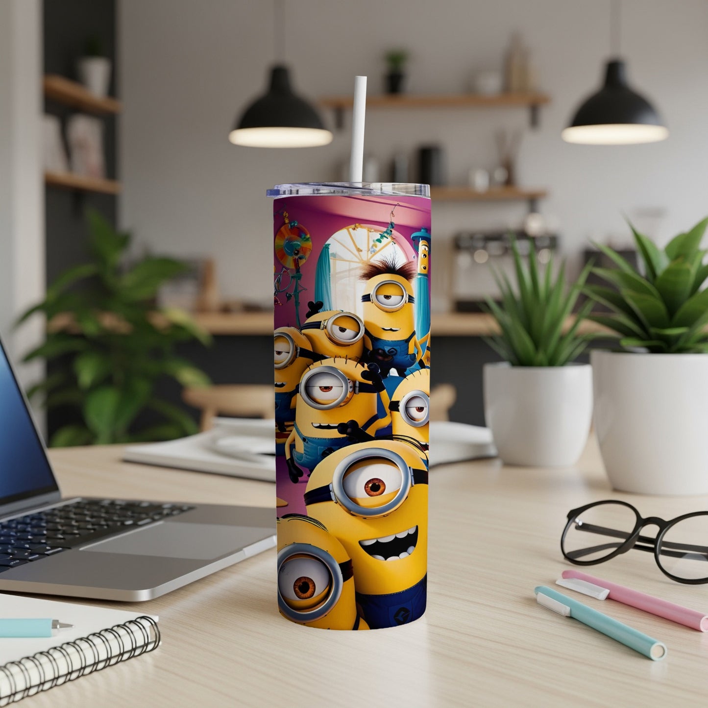 Minions characters on a yellow tumbler with a white straw, on a desk.