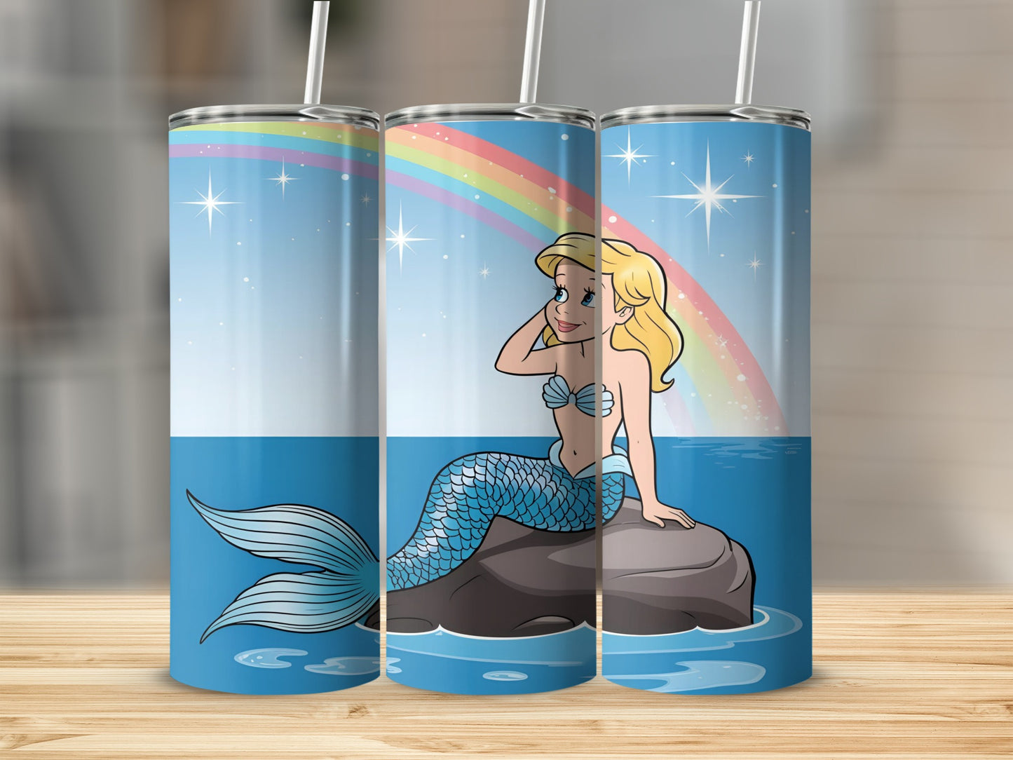 Cartoon mermaid with blue tail sitting on a rock under a rainbow.