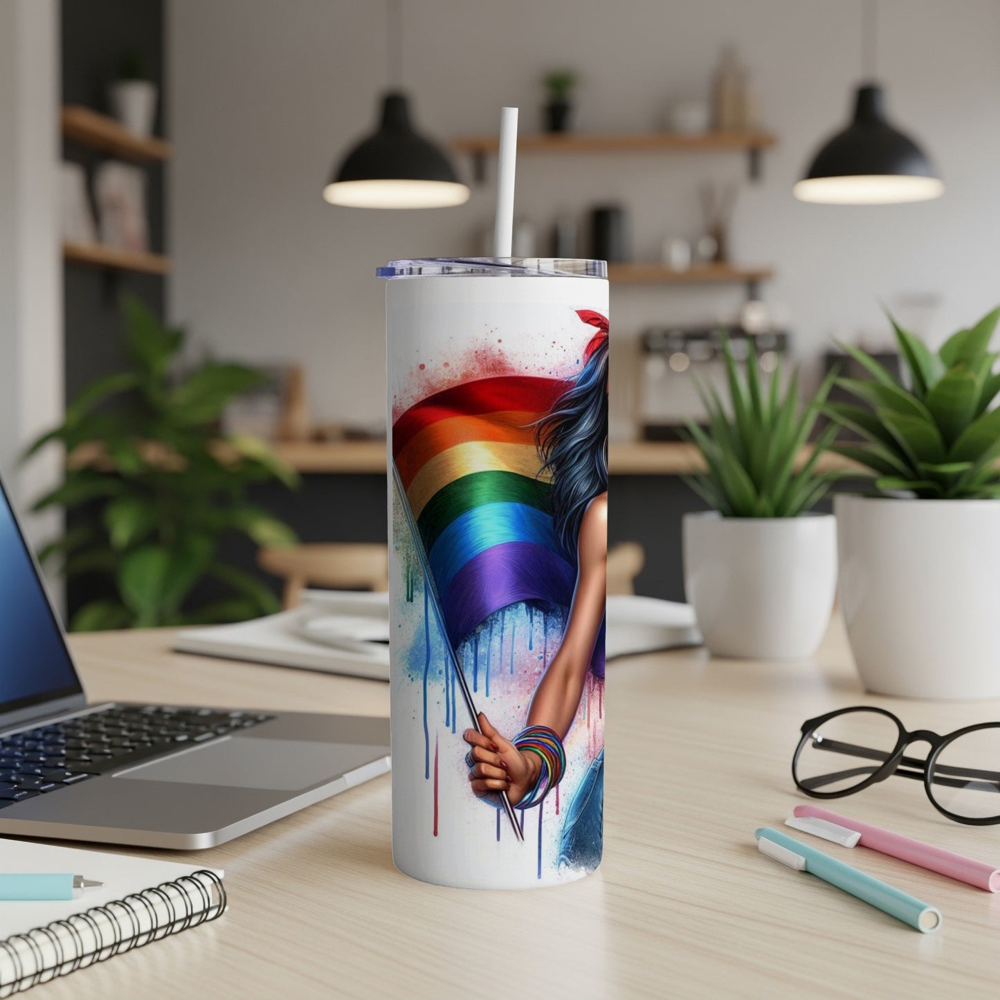 Tumbler with a woman holding a rainbow flag, splattered with paint.