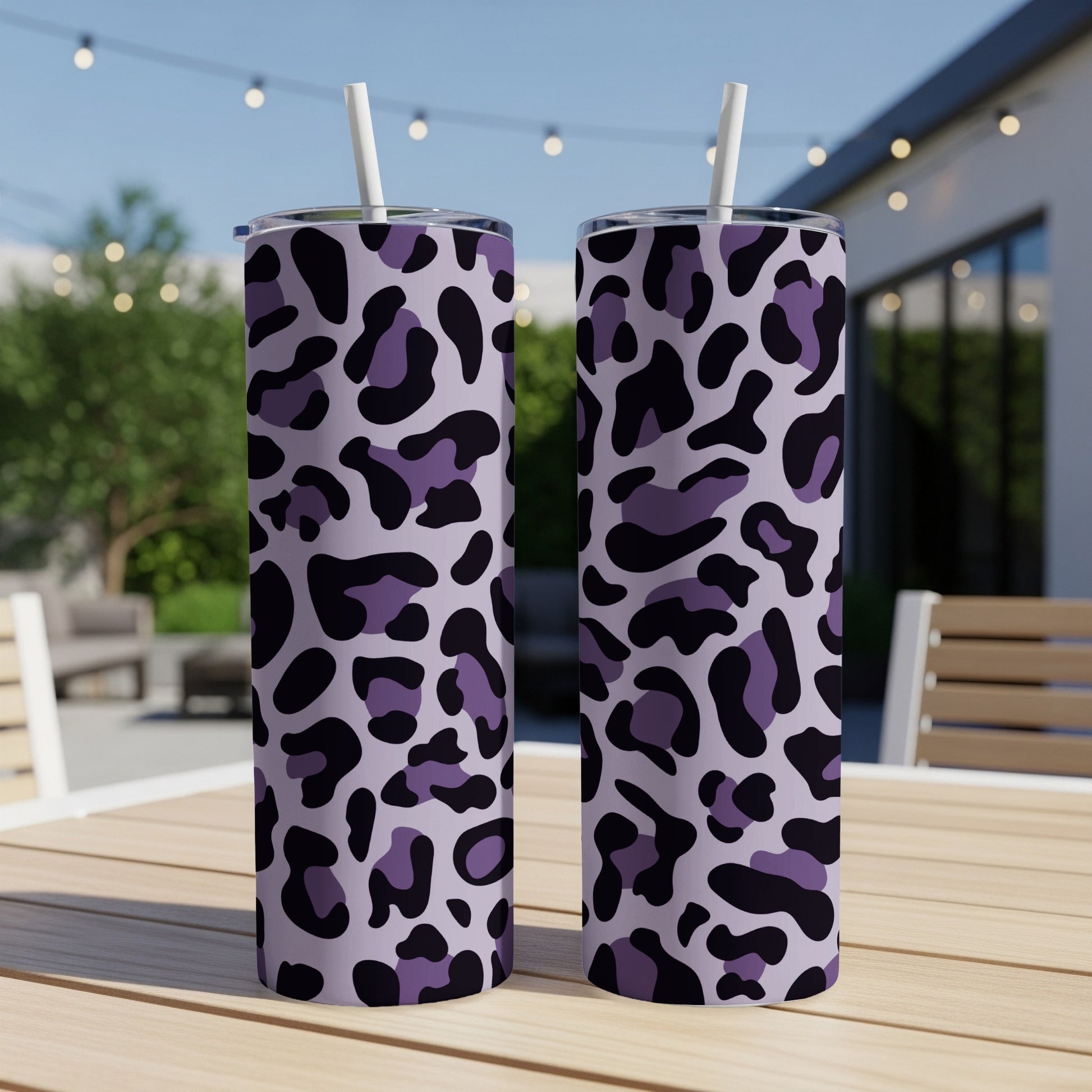 Two tumblers with purple and black leopard print on a wooden table.