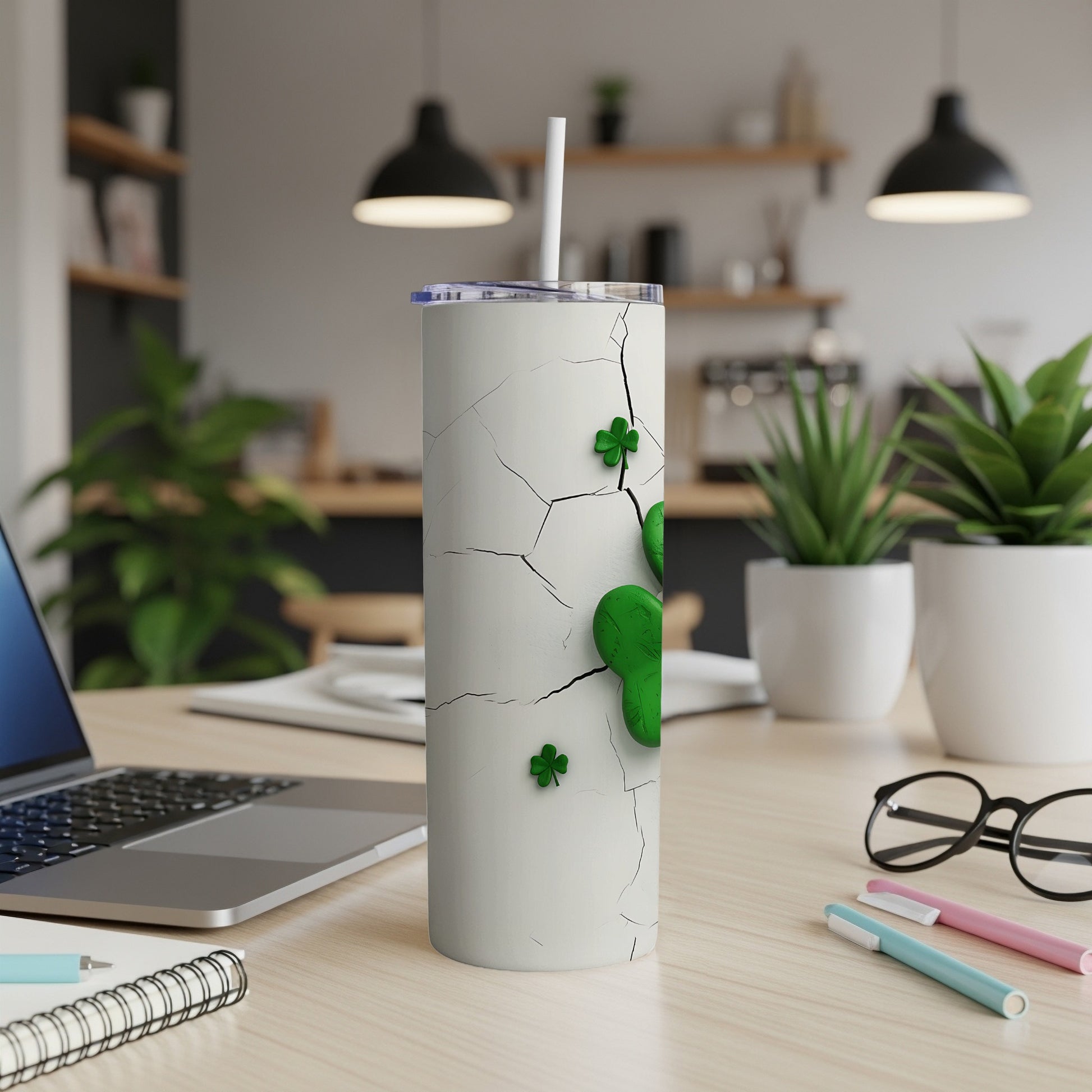 White tumbler with cracked surface and green shamrock designs.