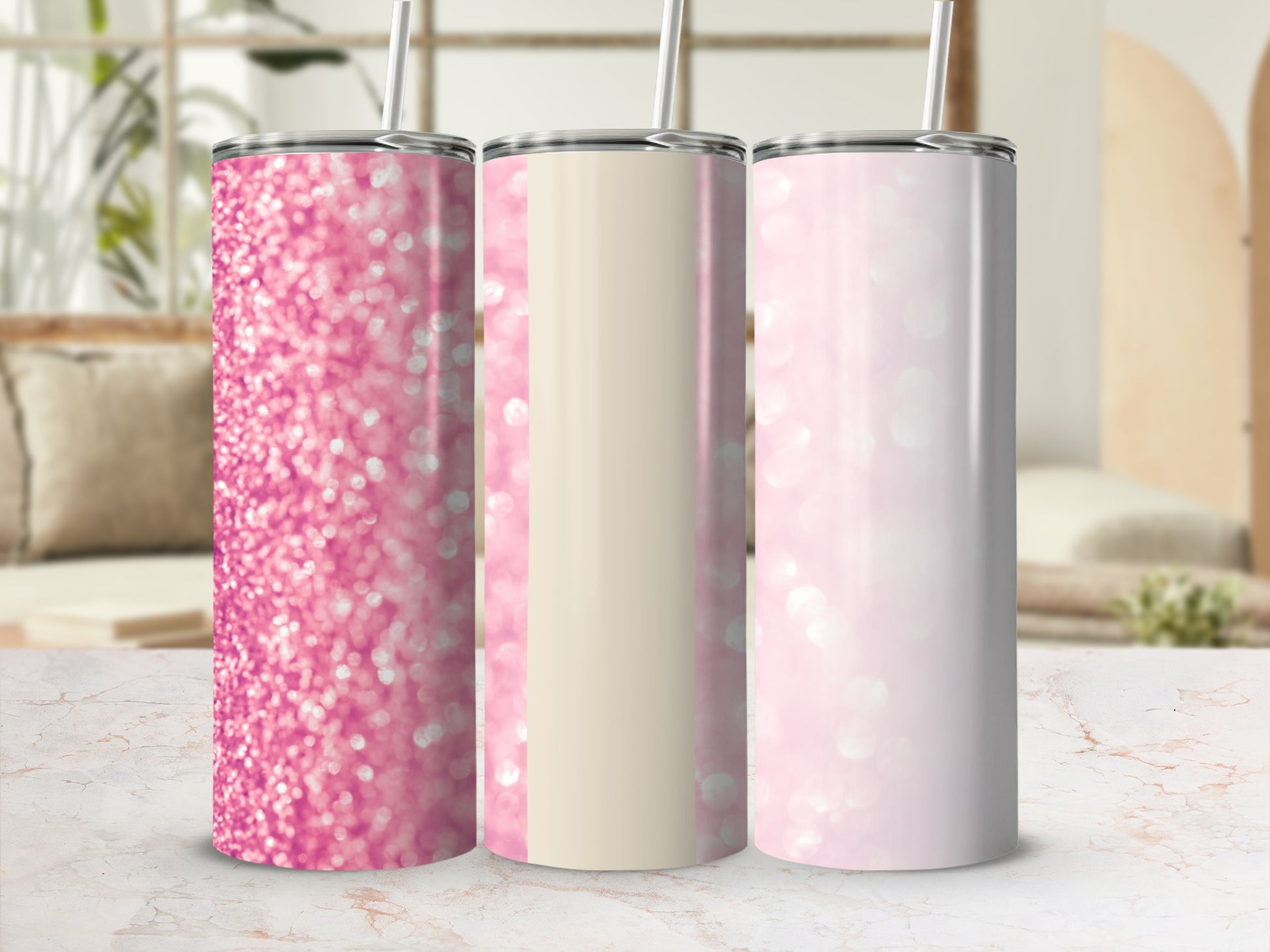 Three glitter tumblers in pink and cream with straws.