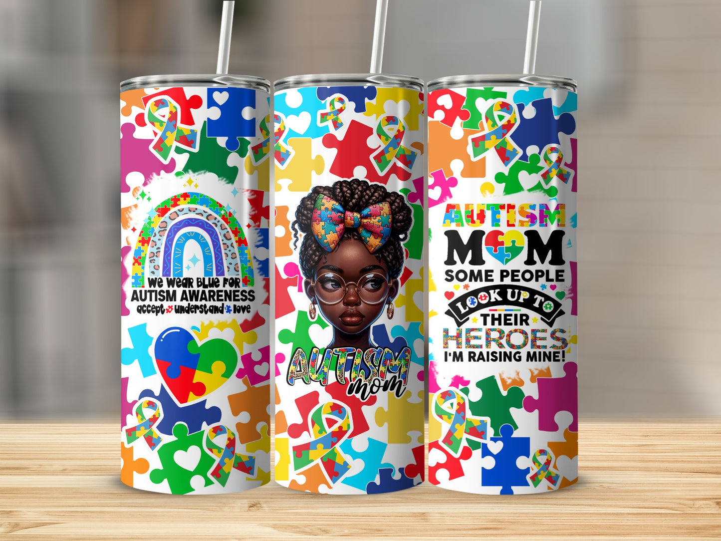 Three tumblers with autism awareness puzzle pieces and text: "We wear blue for autism awareness," "Autism Mom," and "Some people look up to their heroes. I'm raising mine!"