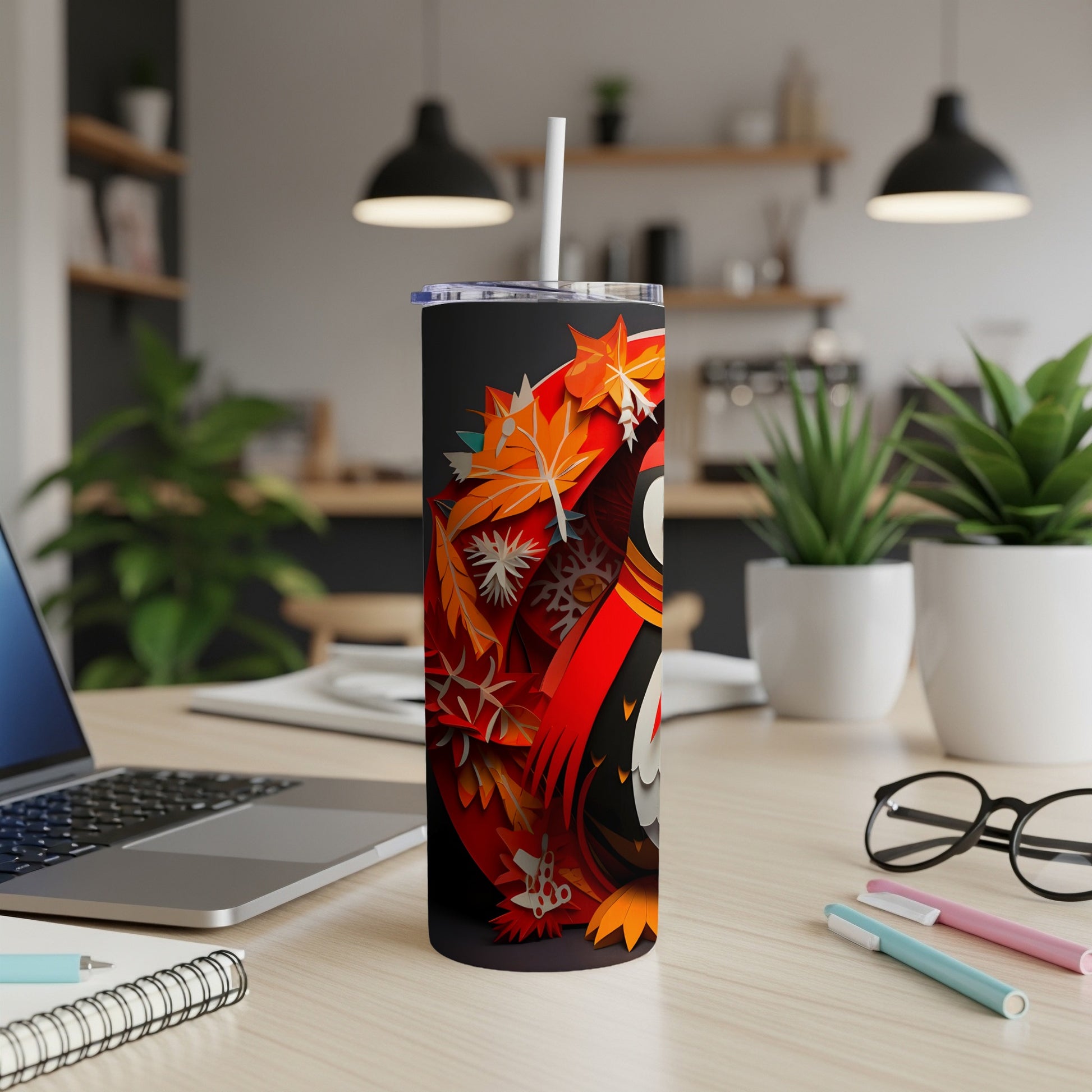 Black tumbler with red and orange autumn leaves and snowflake design.