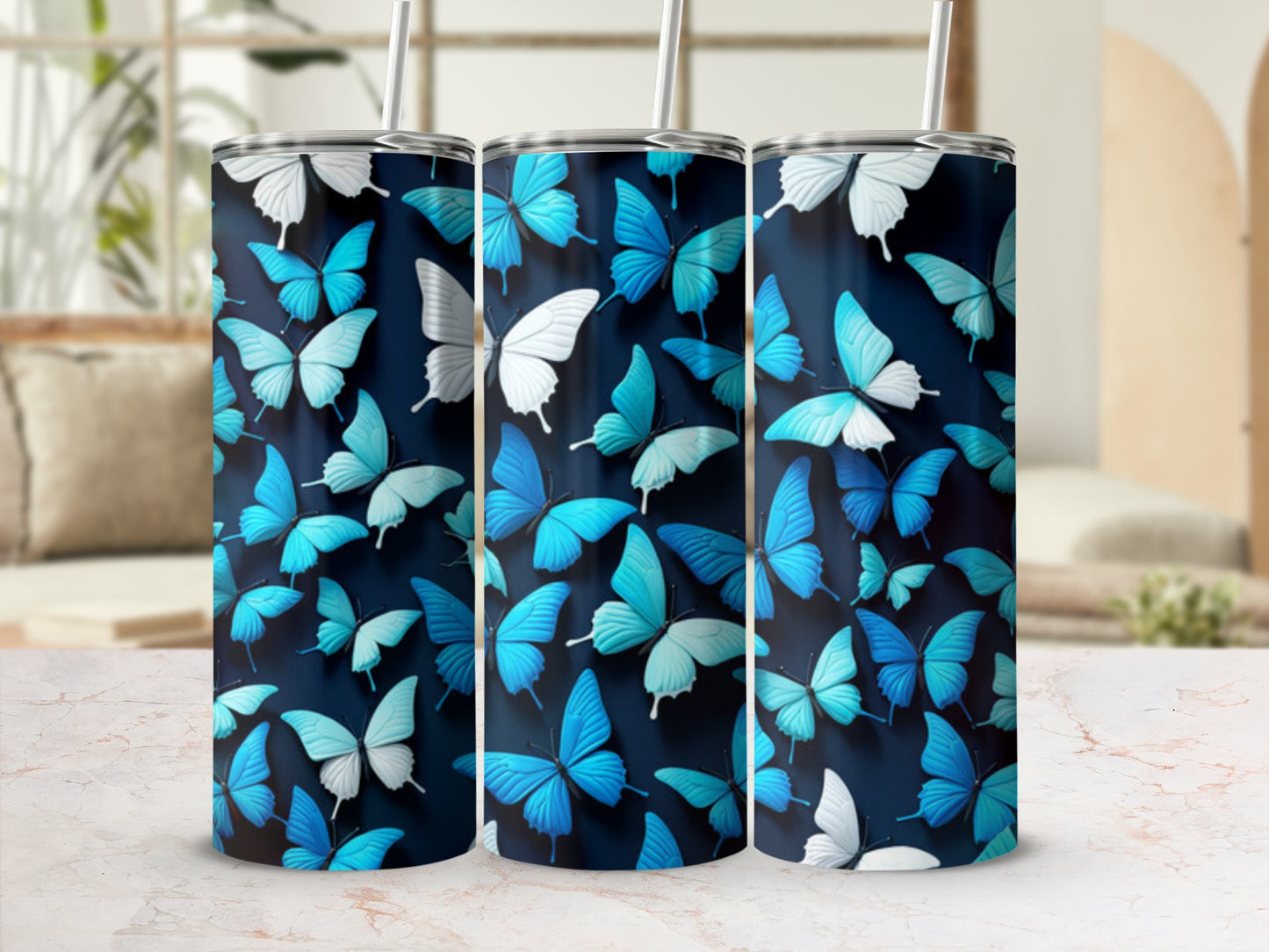 Three blue and white butterfly patterned tumblers with straws.