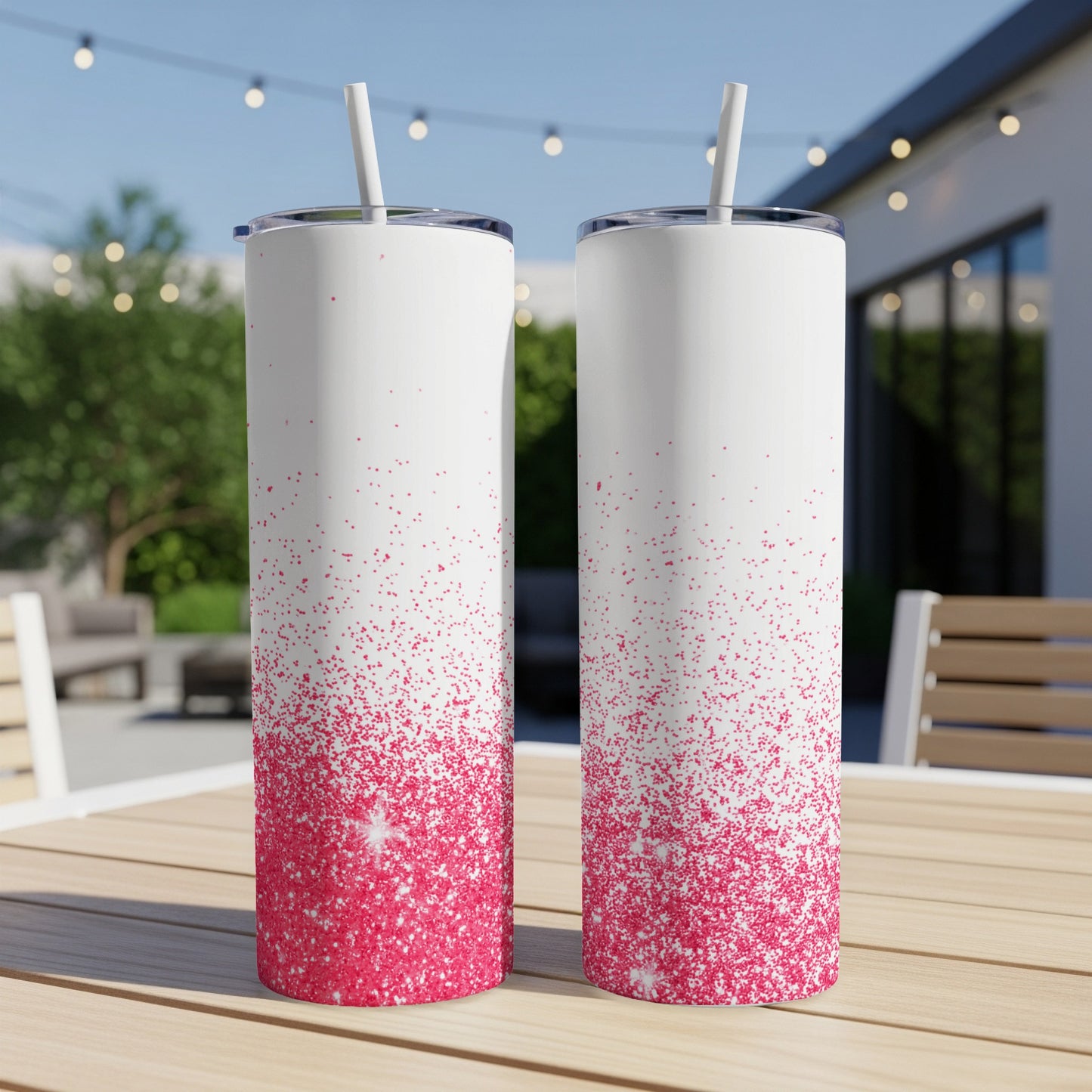 Two white tumblers with pink glitter ombre design on a wooden table.