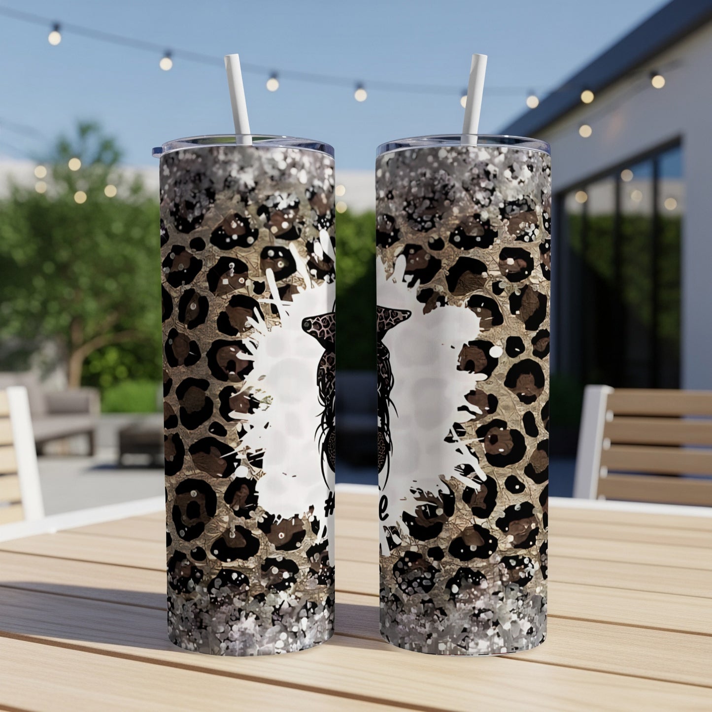 Two tumblers with leopard print and glitter designs on an outdoor table.