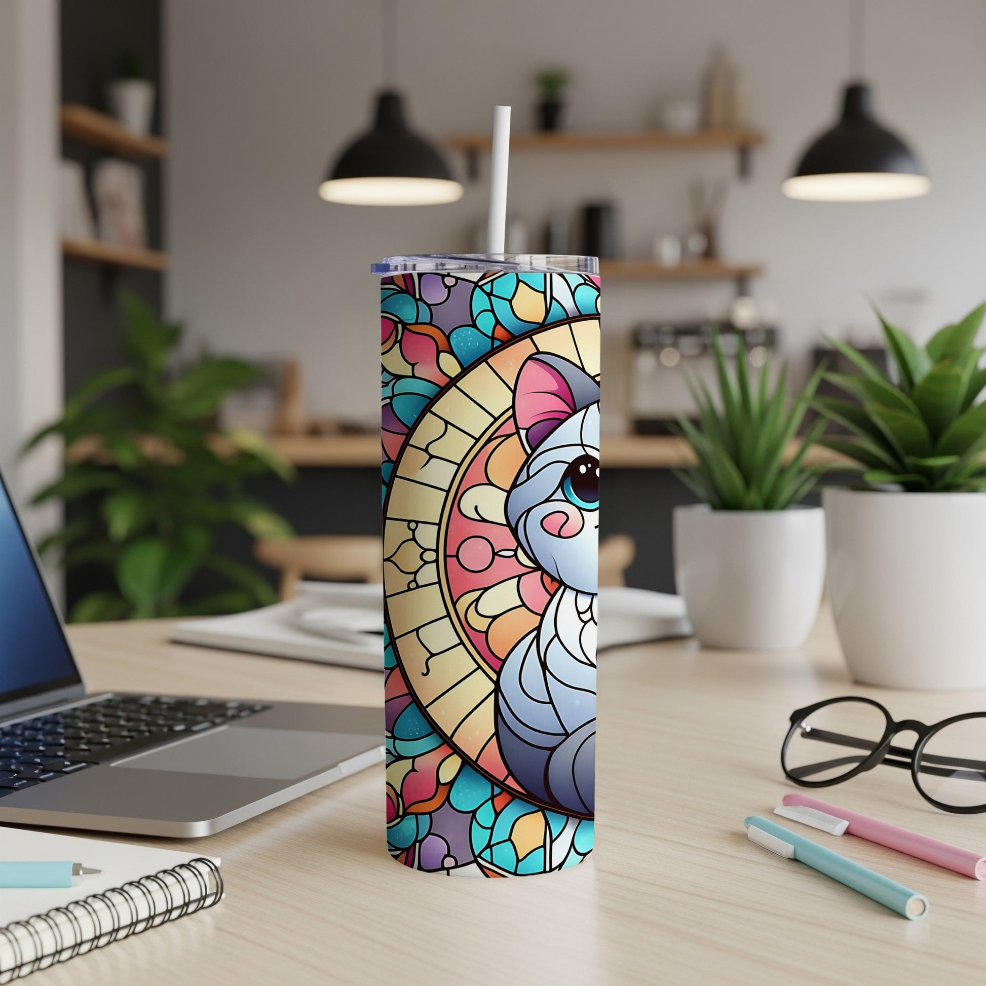 Tumbler with stained-glass cat design on a desk.