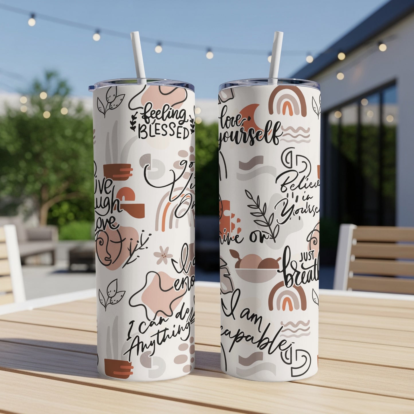 Two white tumblers with abstract wavy line art, rainbows, and motivational text.