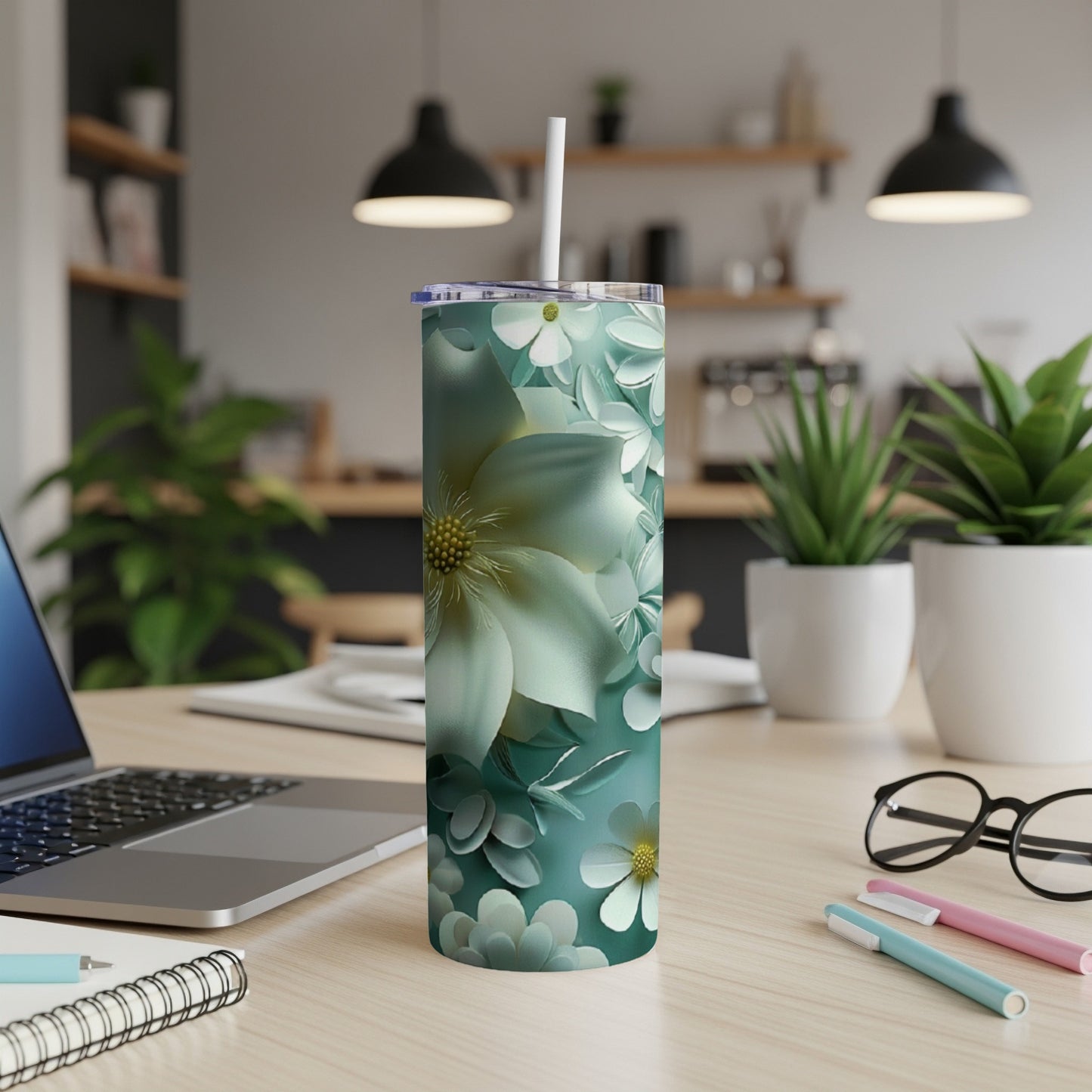Tall, slim tumbler with a light green floral design and a straw.