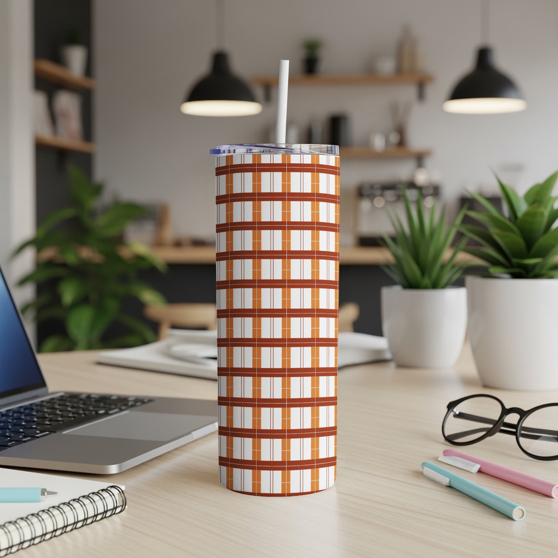 Tall, skinny tumbler with a brown and white plaid pattern and straw.