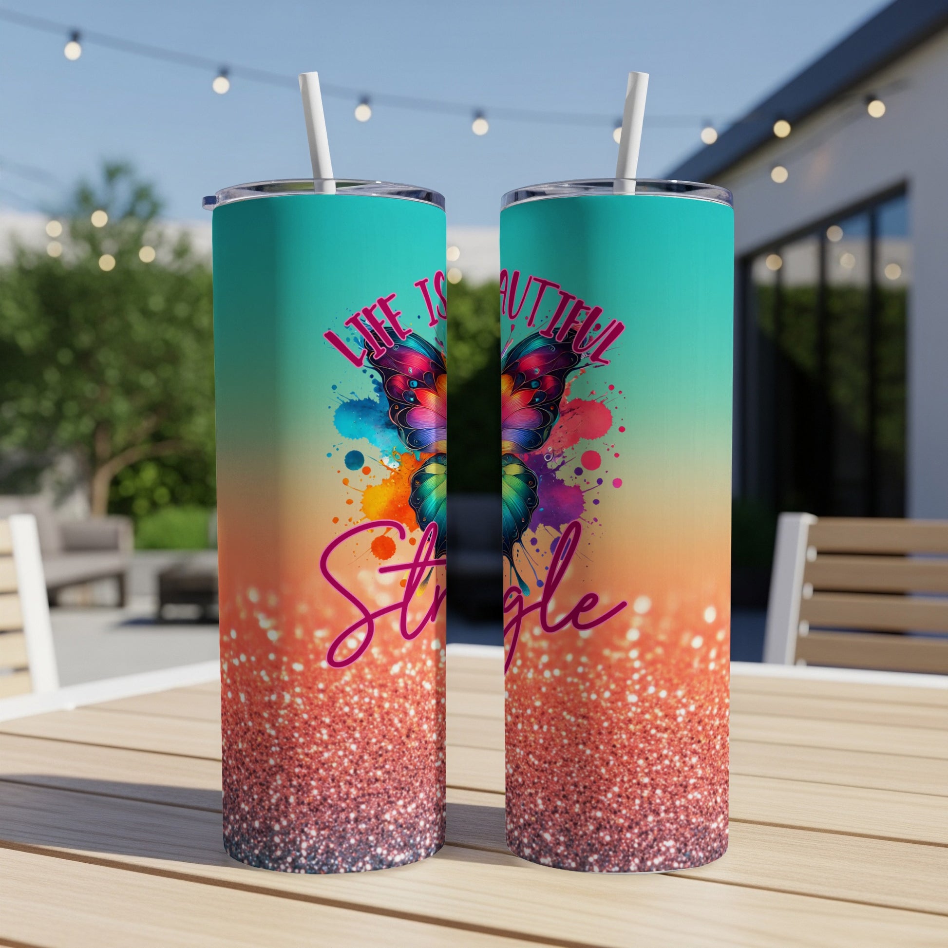 Two tumblers with a colorful butterfly and "Life is beautiful" text on a table.