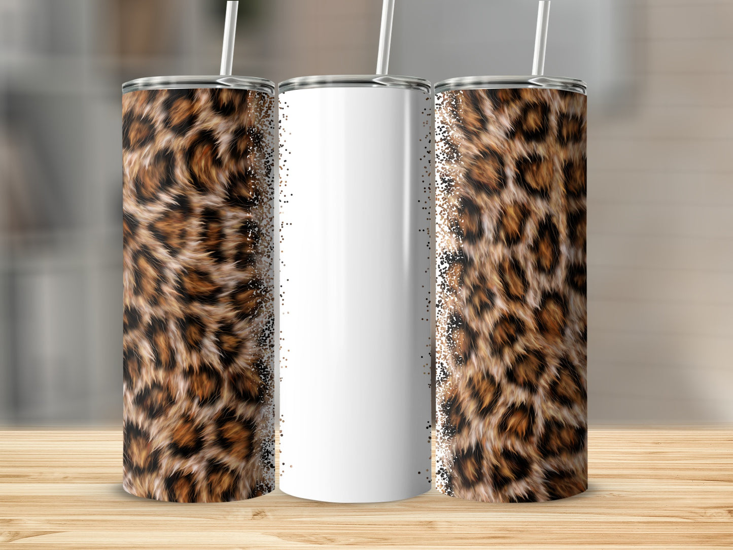 Three tumblers with leopard print and glitter accents, on a wooden surface.