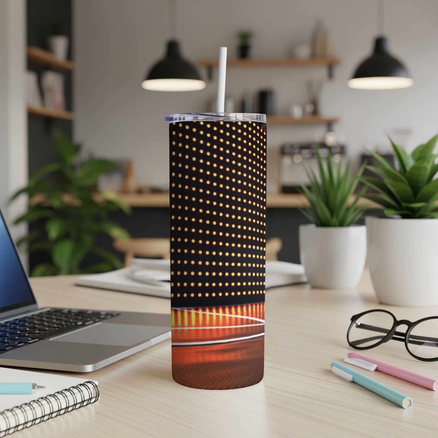 Tall tumbler with polka dot pattern on desk with laptop and plants.