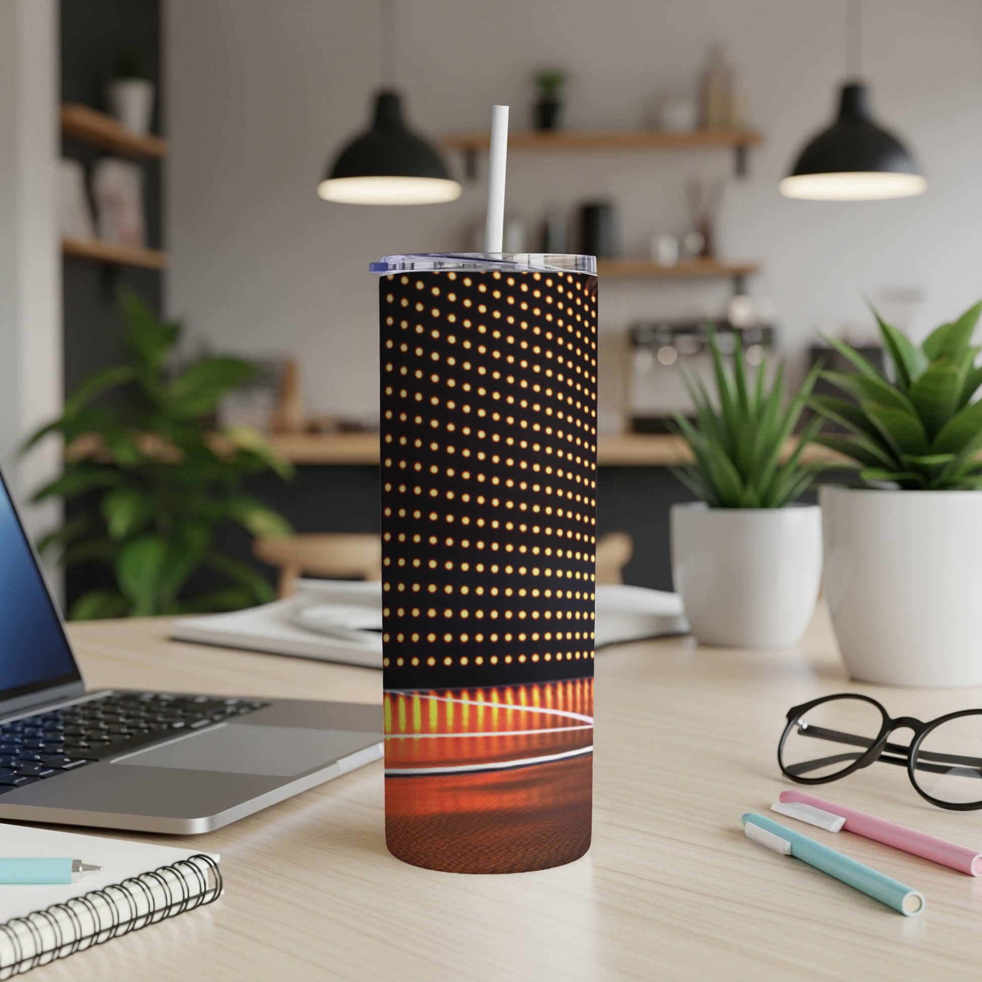 Tall tumbler with polka dot pattern on desk with laptop and plants.