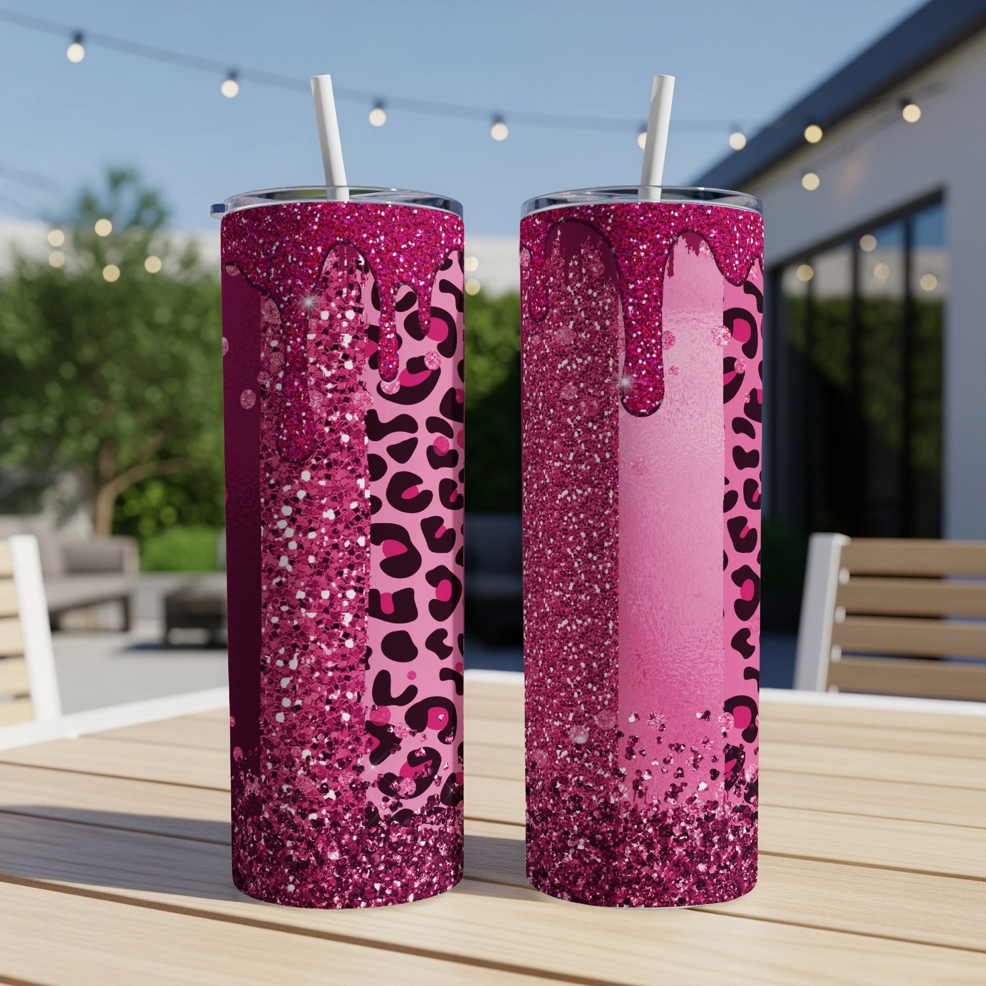 Two pink glitter tumblers with leopard print designs and straws.