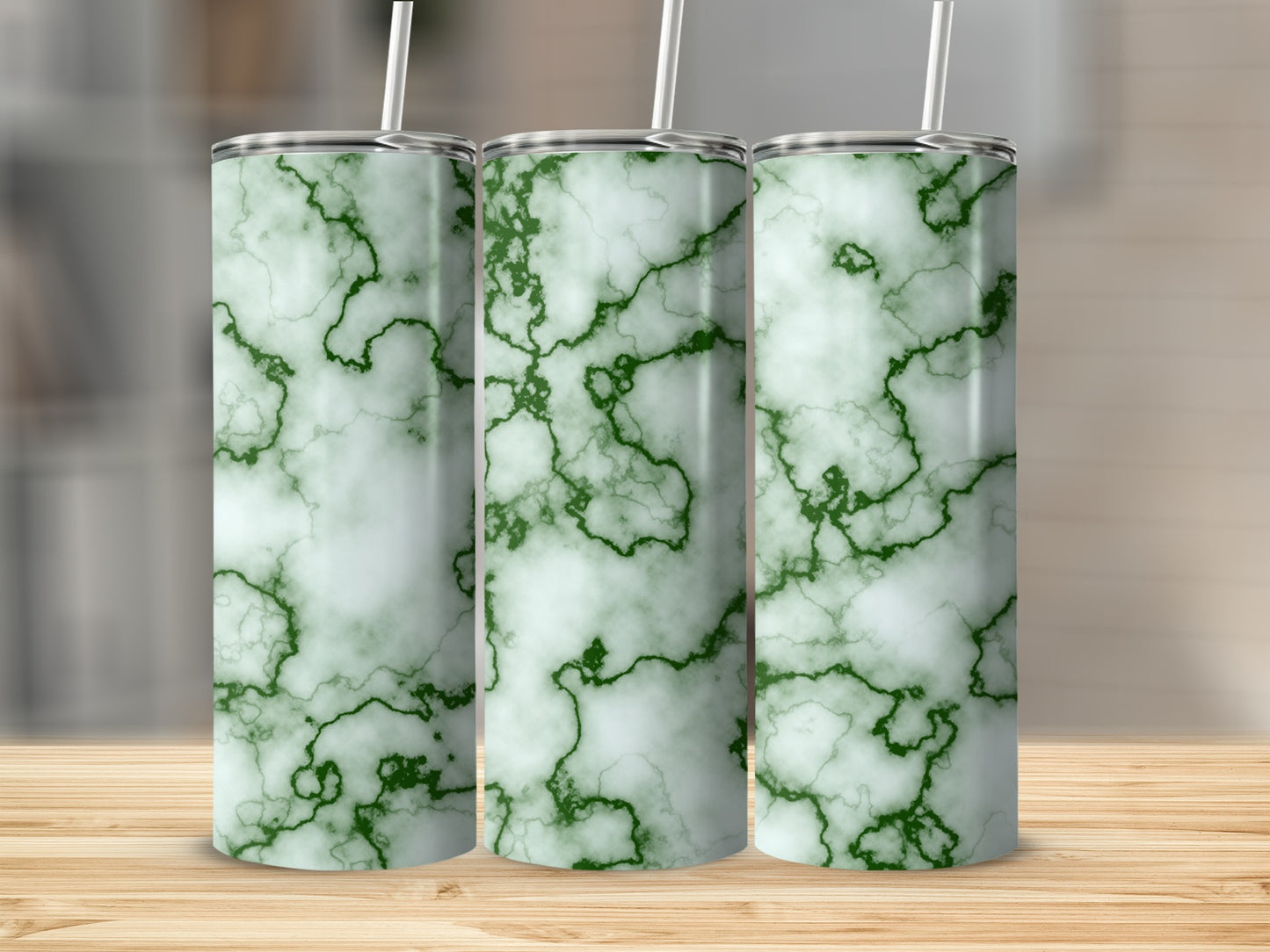 Three tall tumblers with a white and green marble pattern and straws.