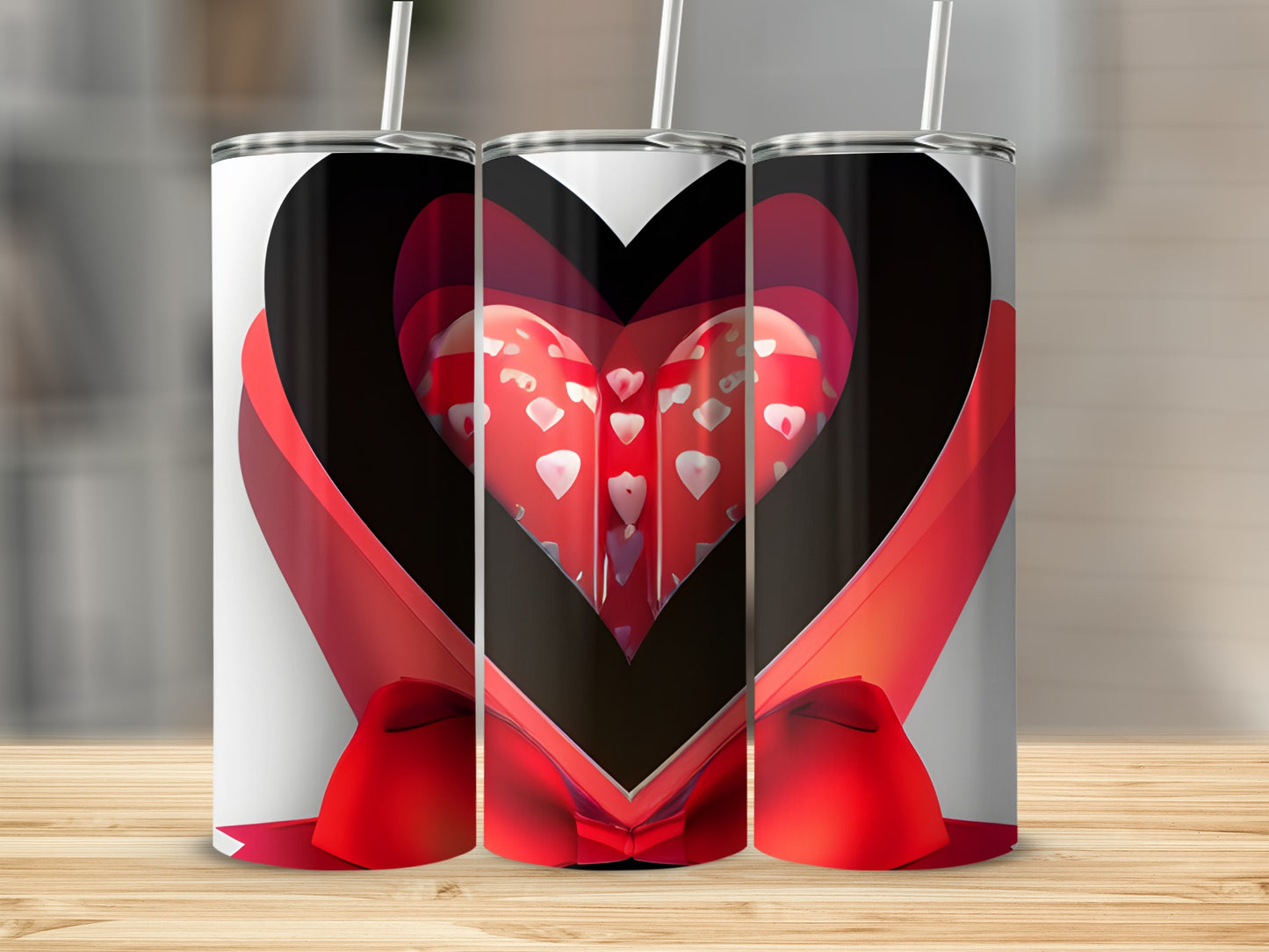 Three tumblers with heart designs and red ribbon, on a wooden surface.