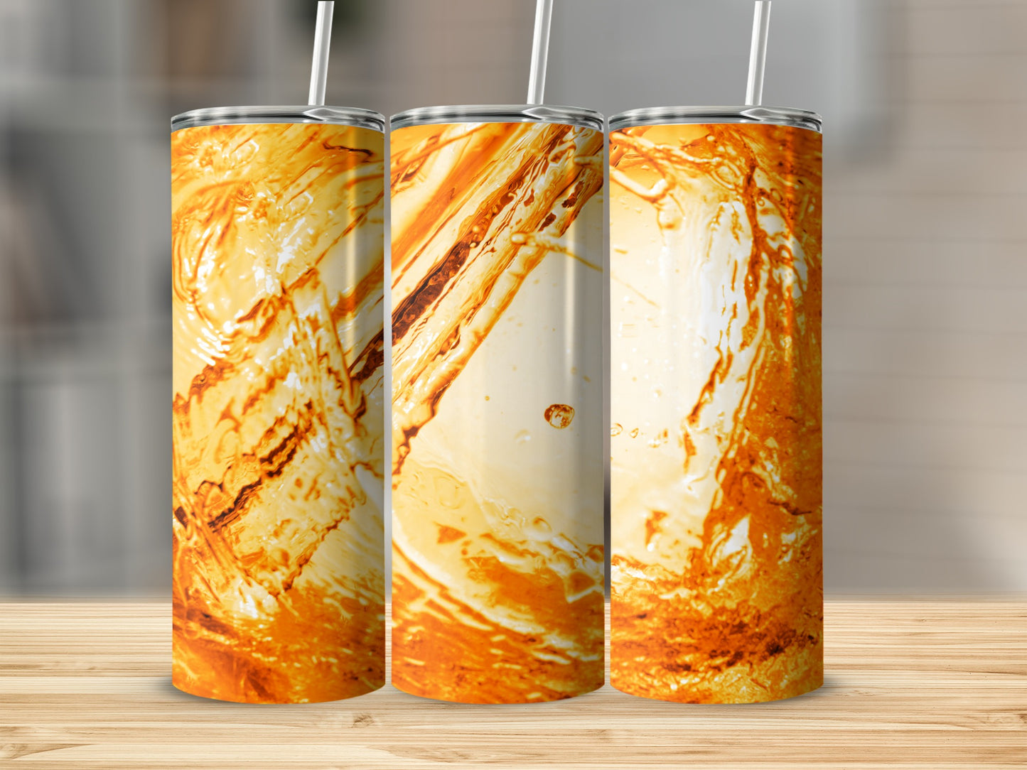 Three tumblers with abstract orange and white marbled patterns and straws.