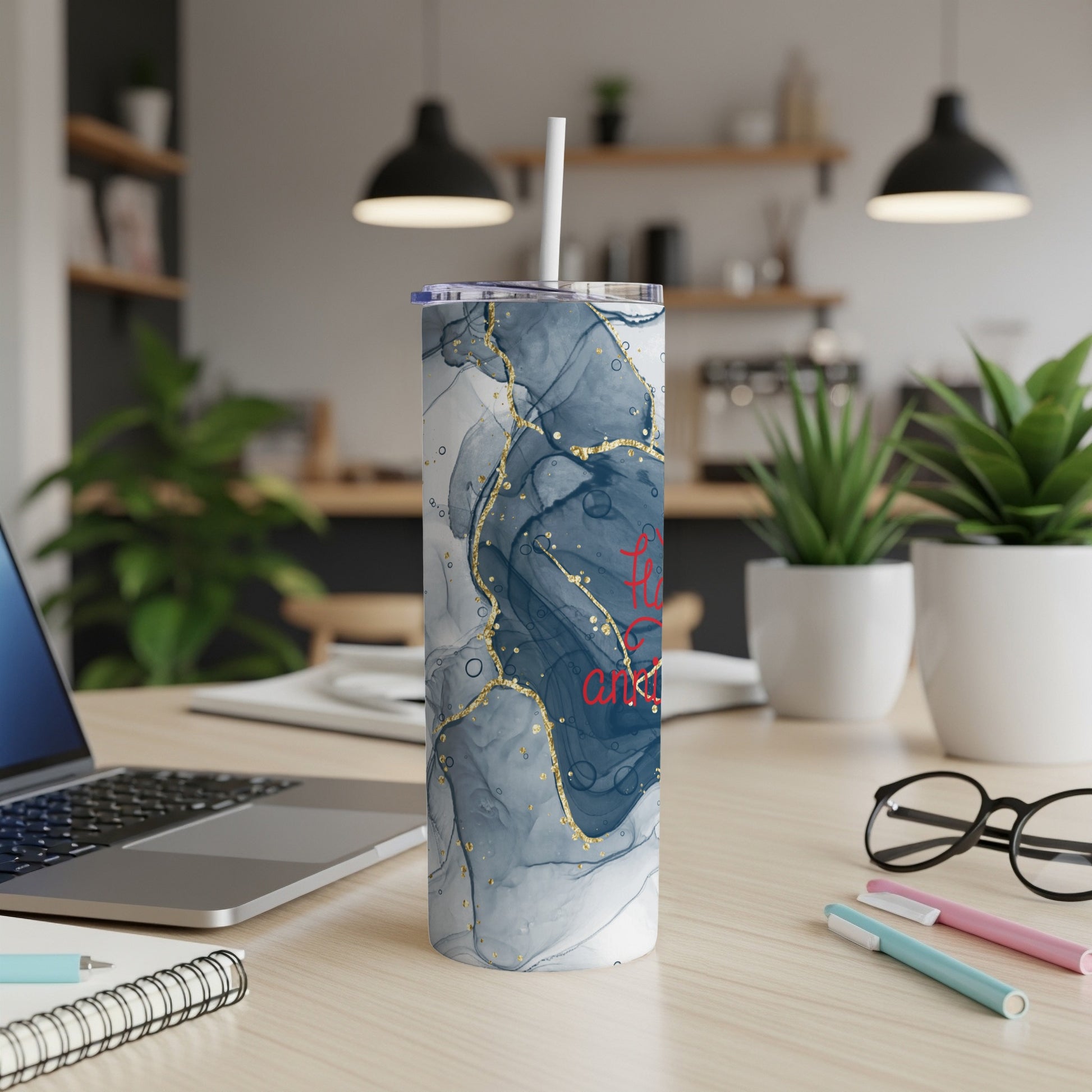White tumbler with marbled blue and gold pattern and red text.