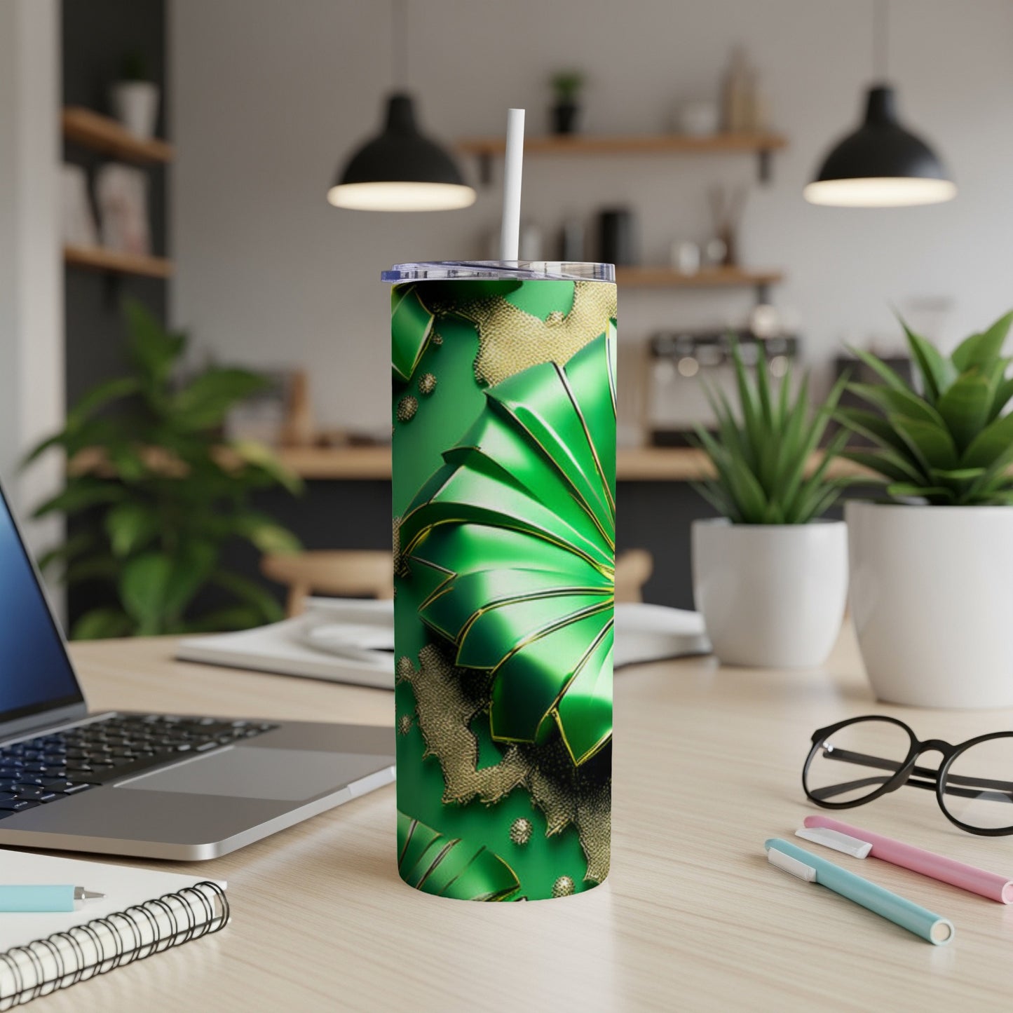 Green tumbler with gold accents and a straw, on a desk.