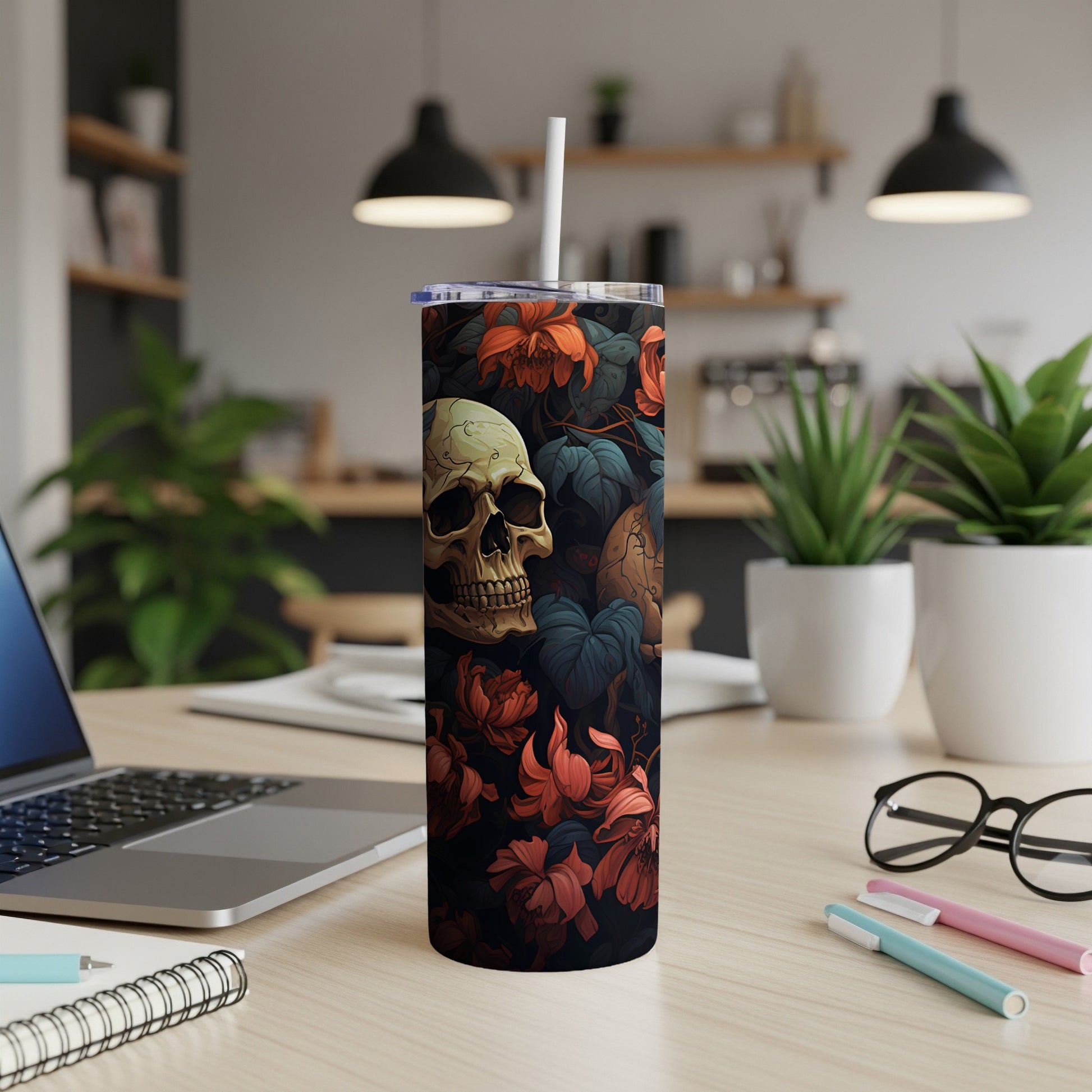 Skull and floral pattern on a black tumbler with a white straw.
