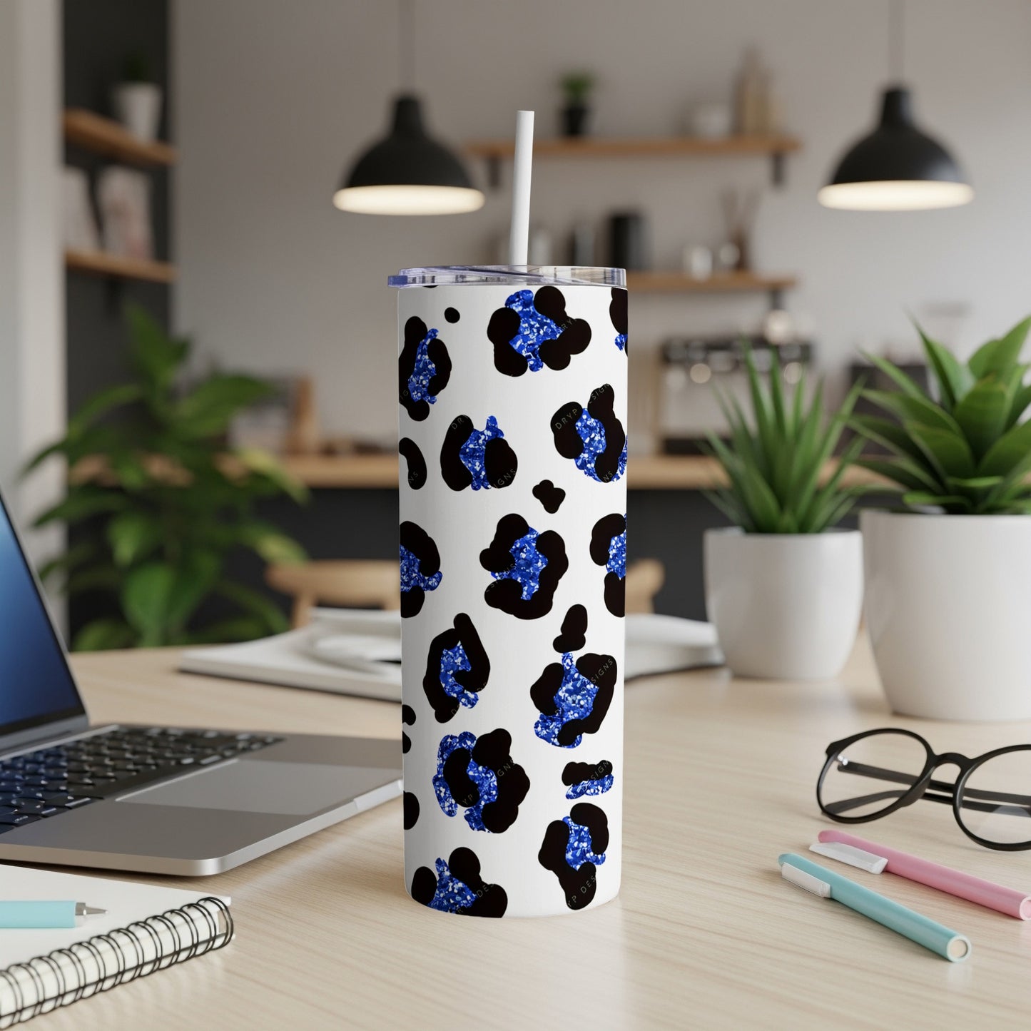 White tumbler with blue and black leopard print, with straw.