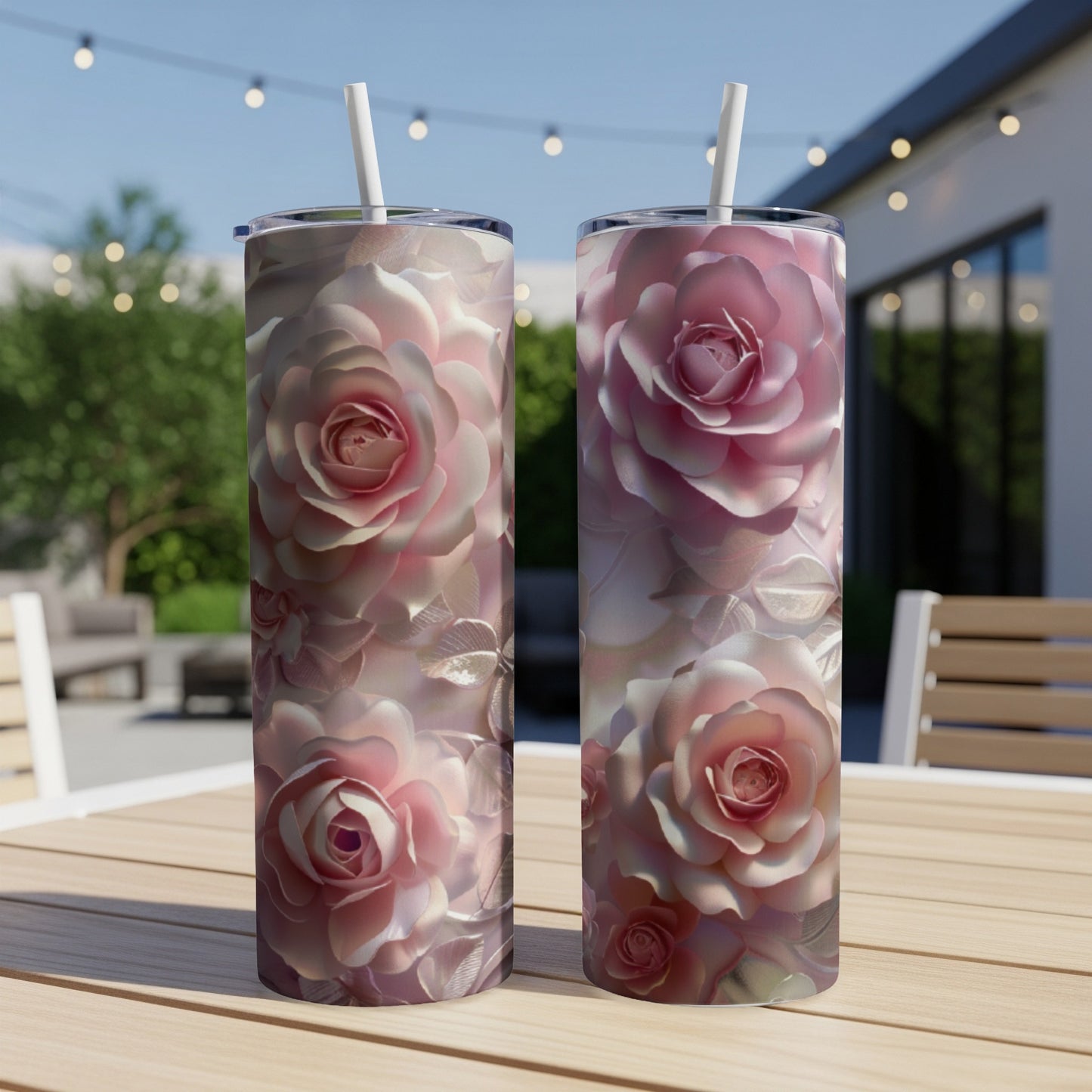 Two pink camellia flower tumblers with straws on a wooden table.