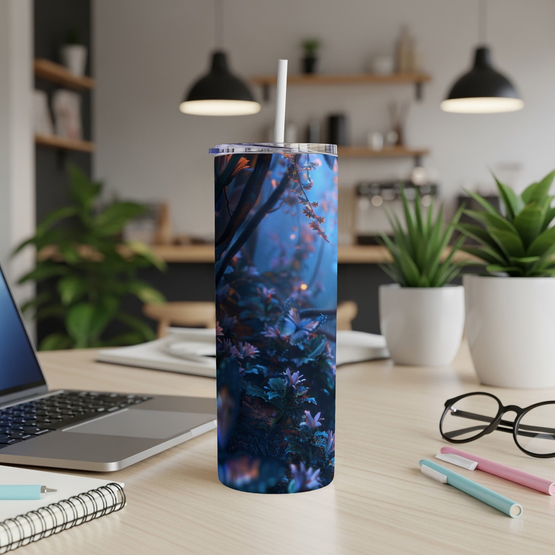 Tall tumbler with a glowing forest scene on a desk.