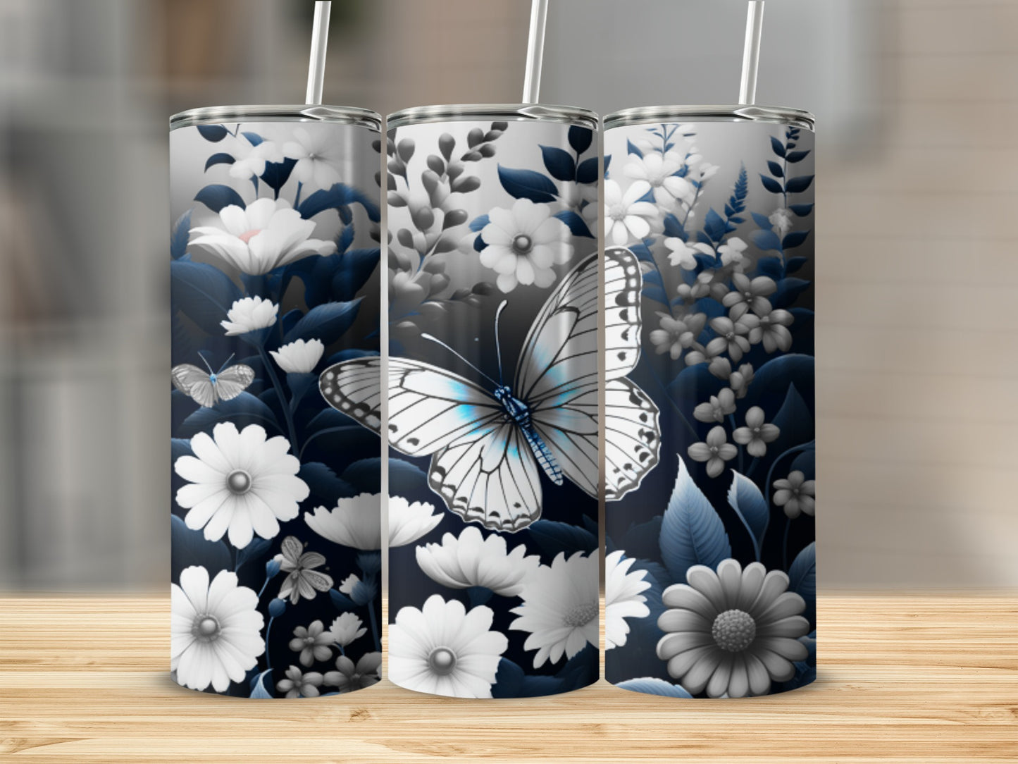 Three floral tumblers with butterflies and white flowers on a wooden surface.