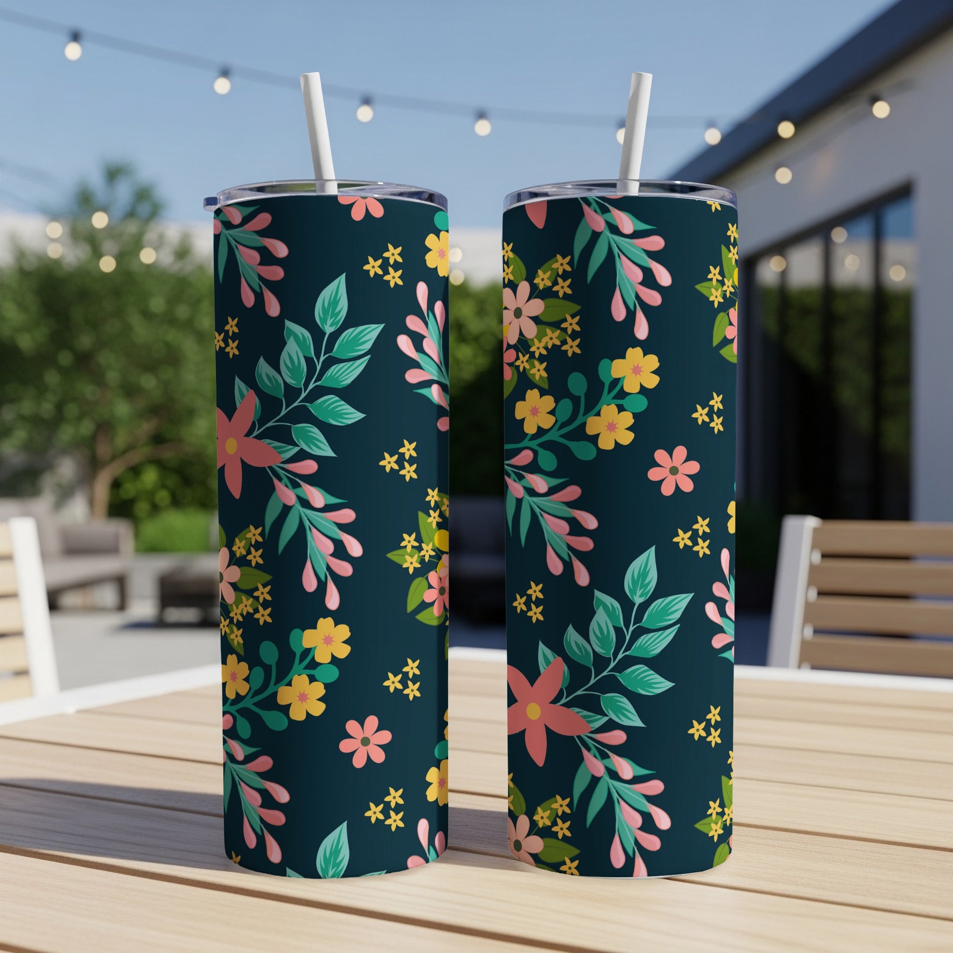 Two dark blue tumblers with a floral pattern of pink, yellow, and green leaves and flowers.
