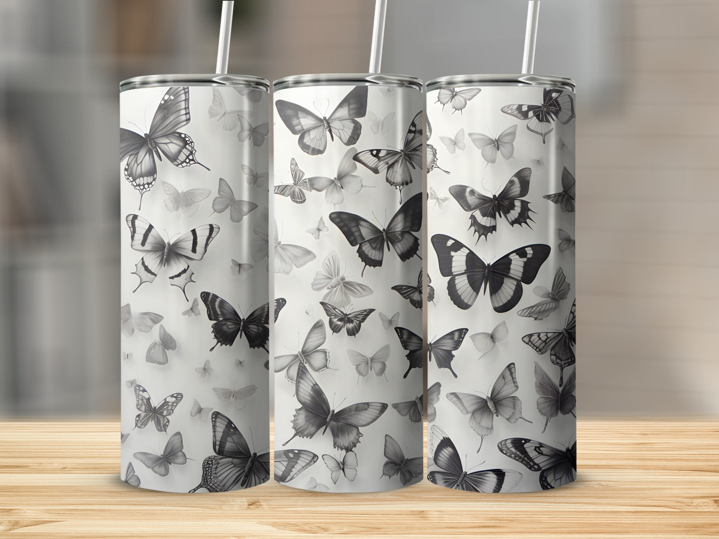 Three tumblers with a repeating pattern of black and white butterflies.