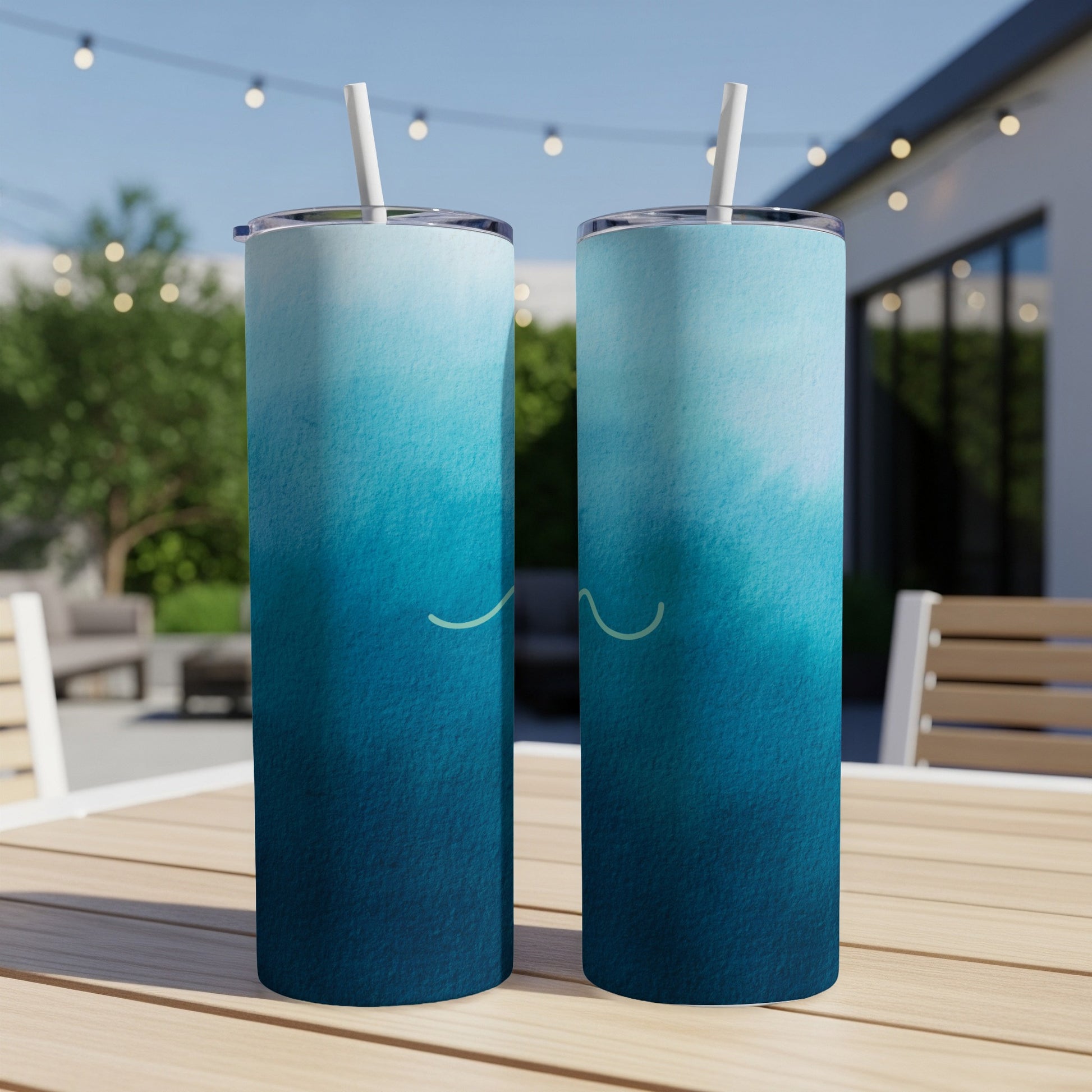 Two tall, skinny tumblers with a blue ombre design and a subtle wave graphic.