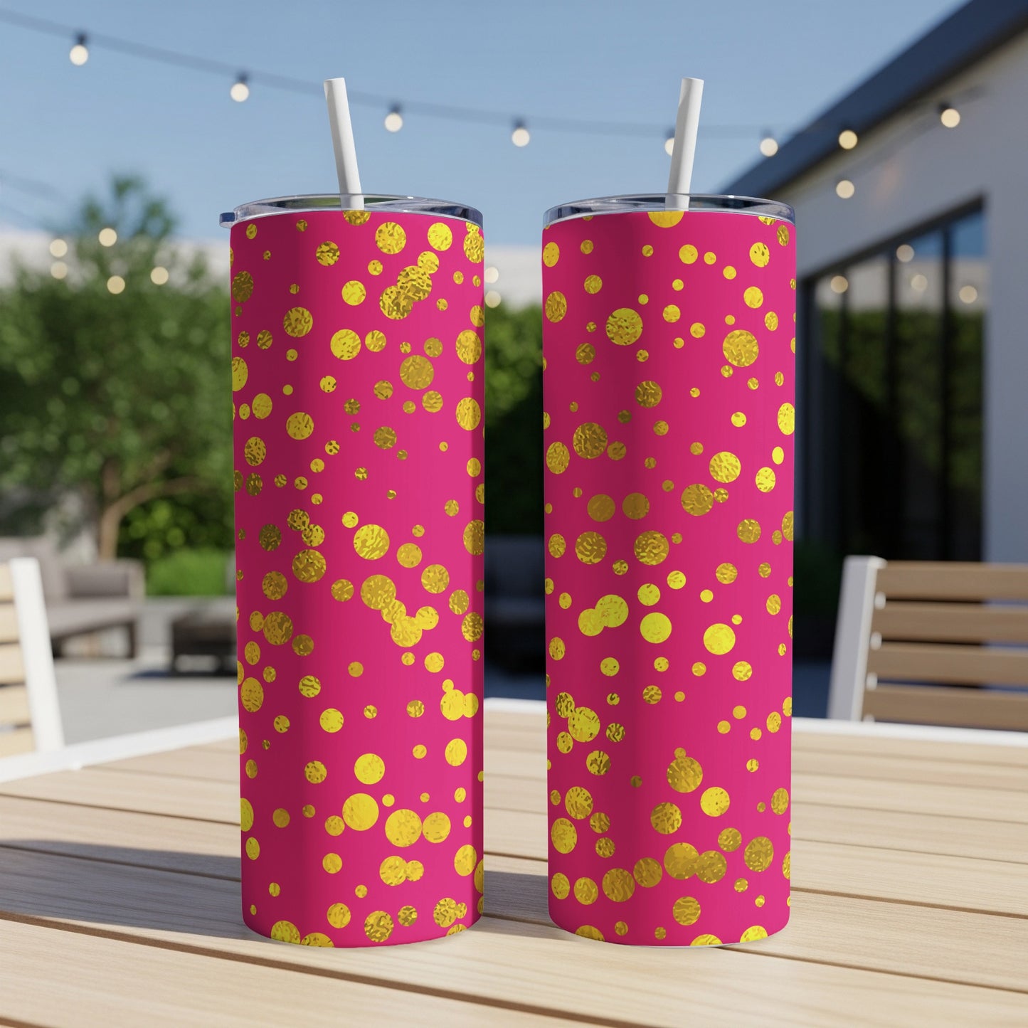 Two pink tumblers with gold polka dots, each with a white straw.