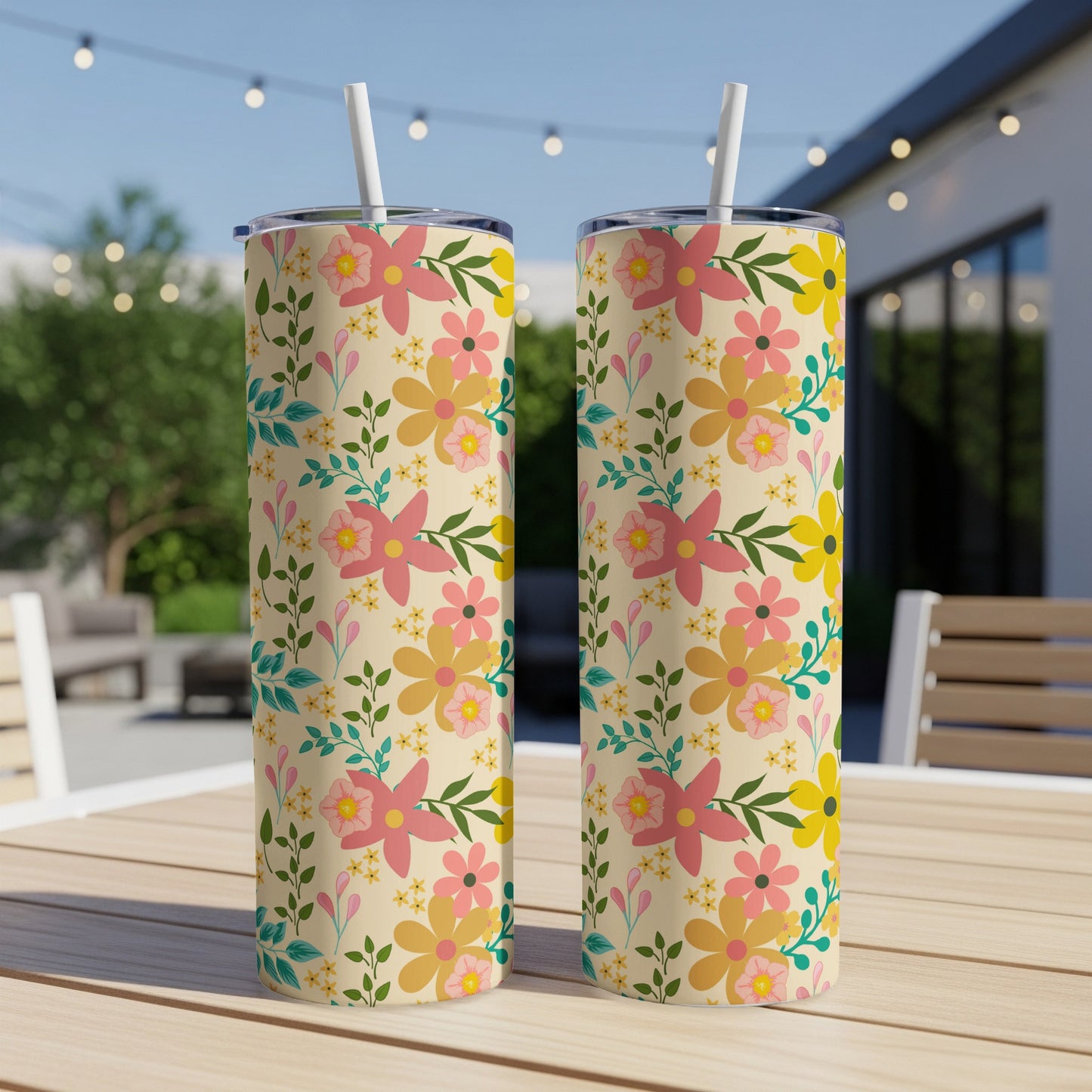 Two tumblers with a retro floral pattern on a wooden table outdoors.