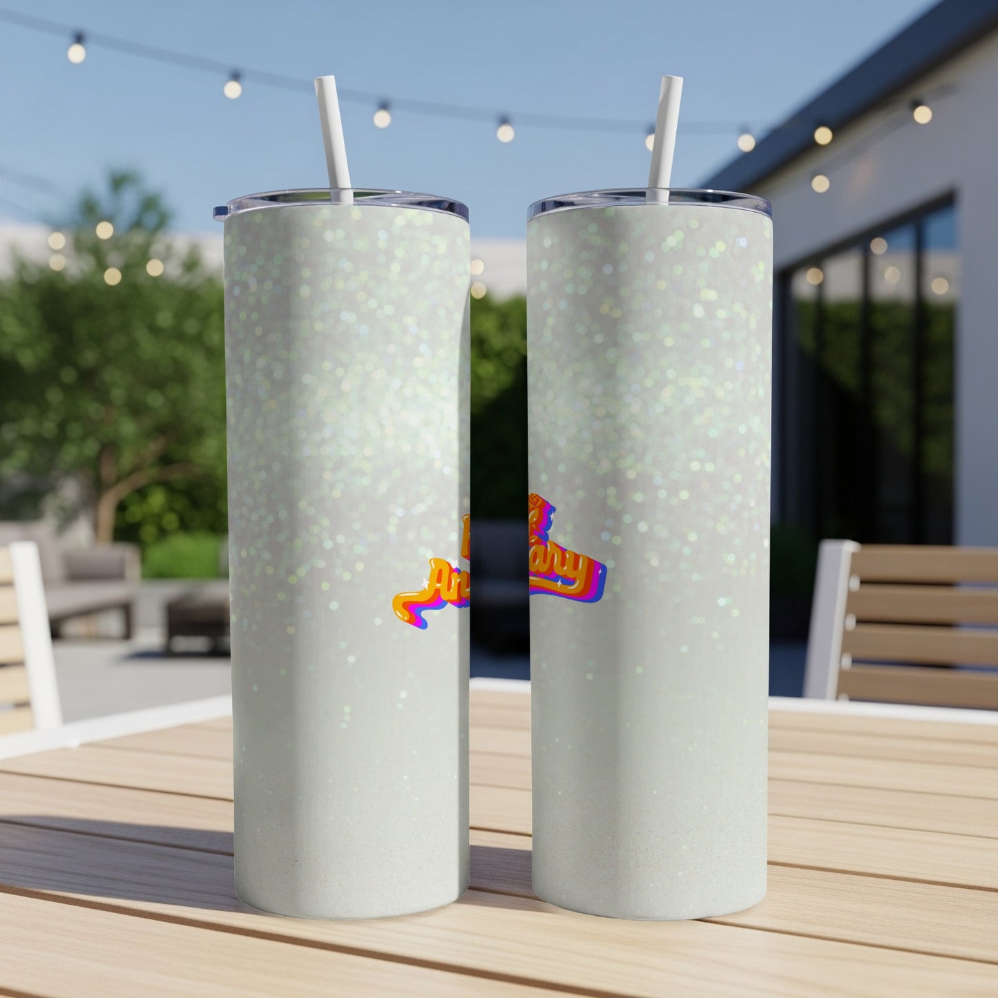 Two white glitter tumblers with a colorful "Happy Birthday" graphic on a table.
