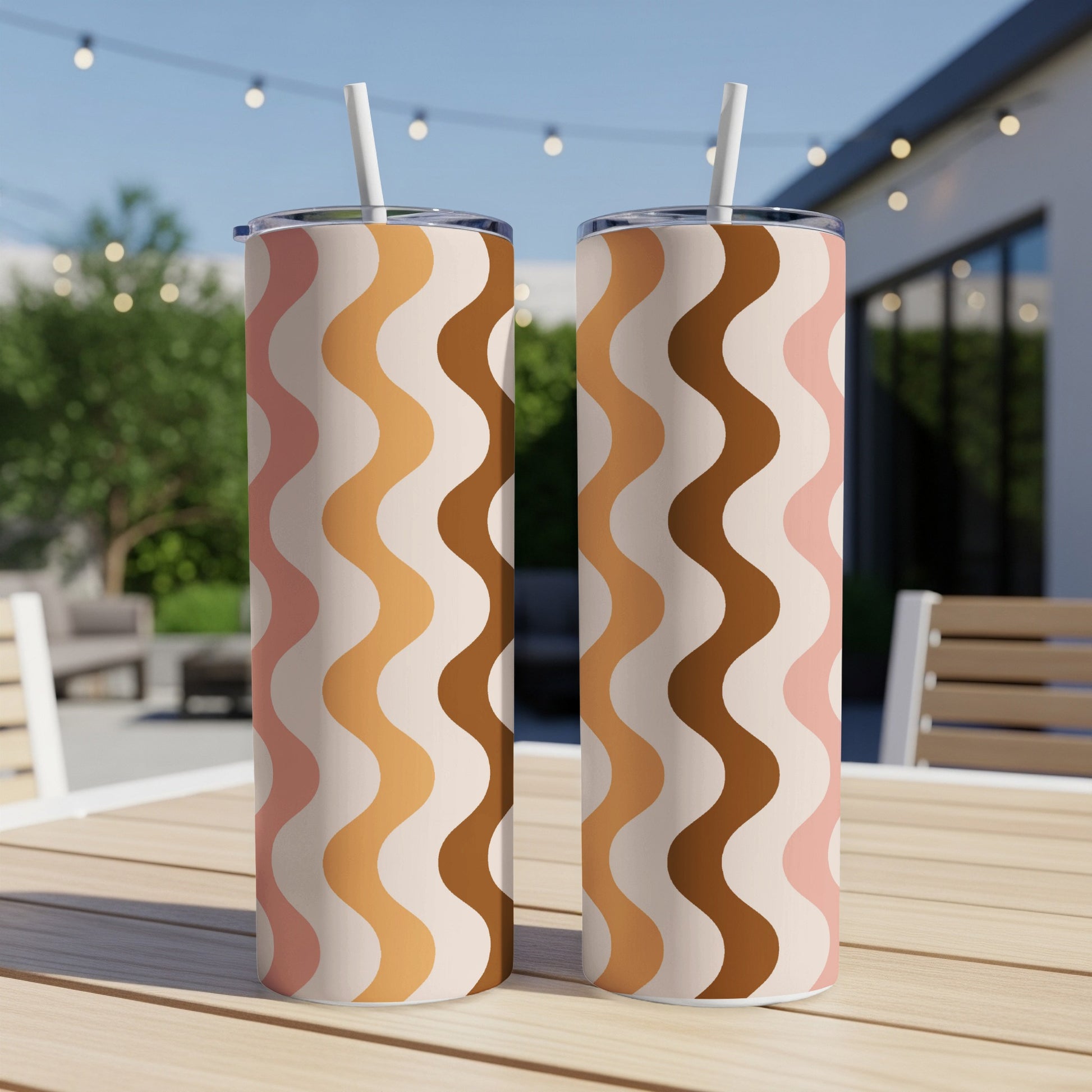 Two tumblers with a wavy cream, pink, tan, and brown pattern on a wooden table.