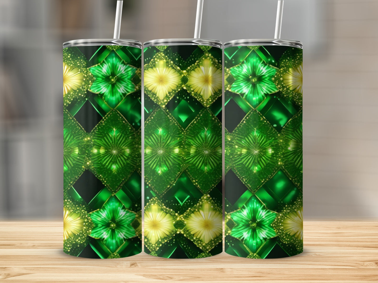 Three green and gold floral patterned tumblers with straws stand on a wooden surface.