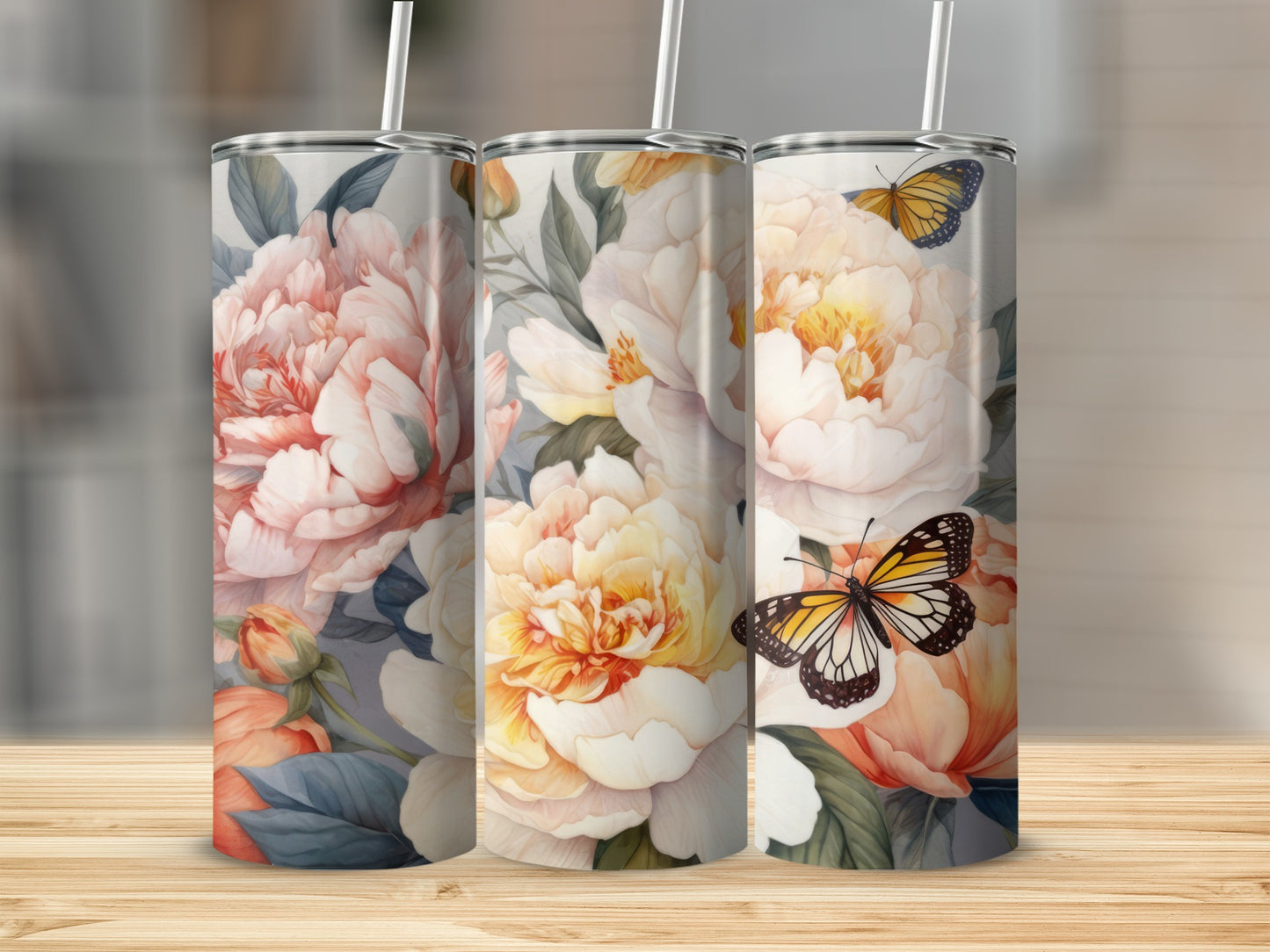 Three tumblers featuring large peonies and butterflies on a wooden surface.