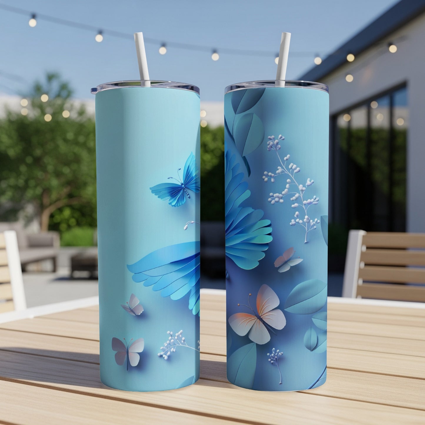 Two light blue tumblers with butterfly and floral designs sit on a wooden table.