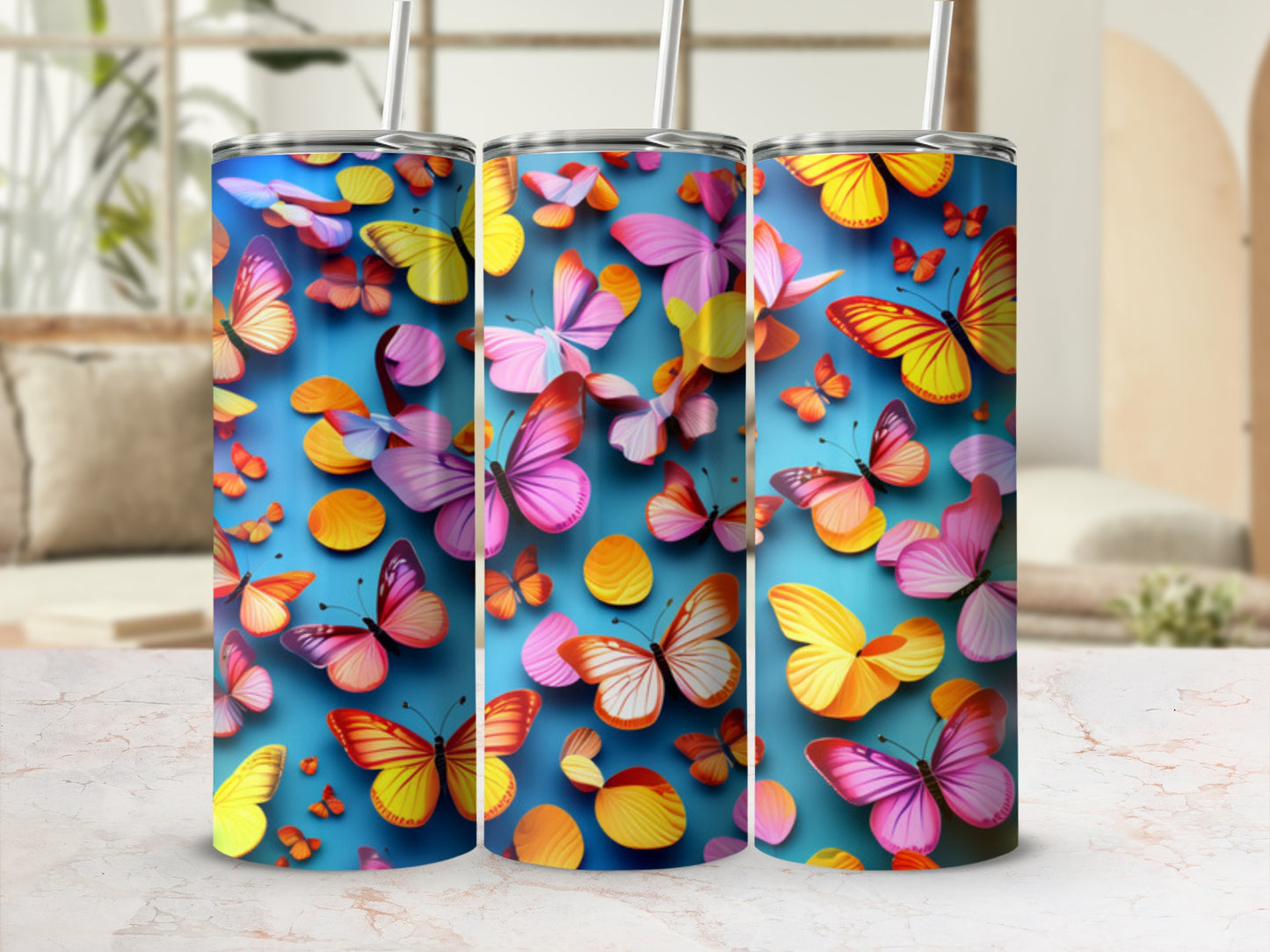 Three tumblers with colorful butterflies and gold accents on a blue background.