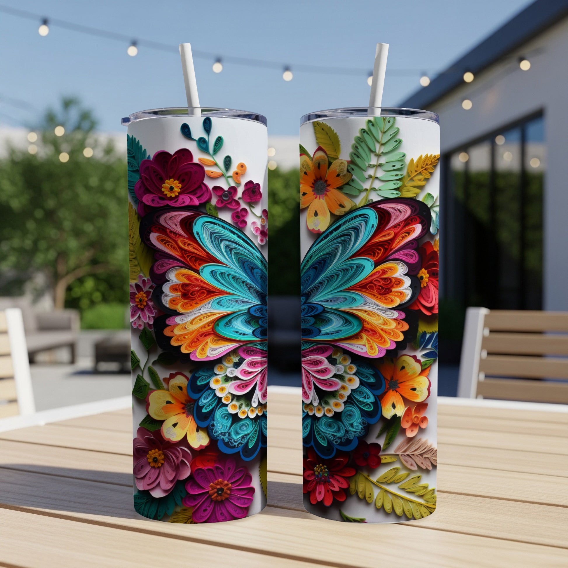 Two colorful butterfly-themed tumblers with floral designs sit on a wooden table.