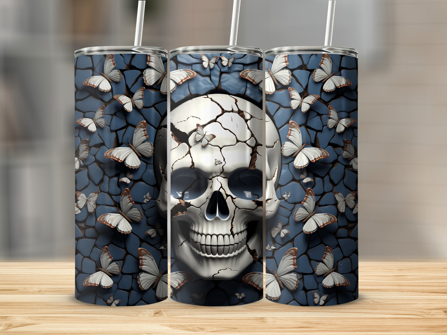Cracked skull with butterflies on a patterned blue background, shown on three tumblers.