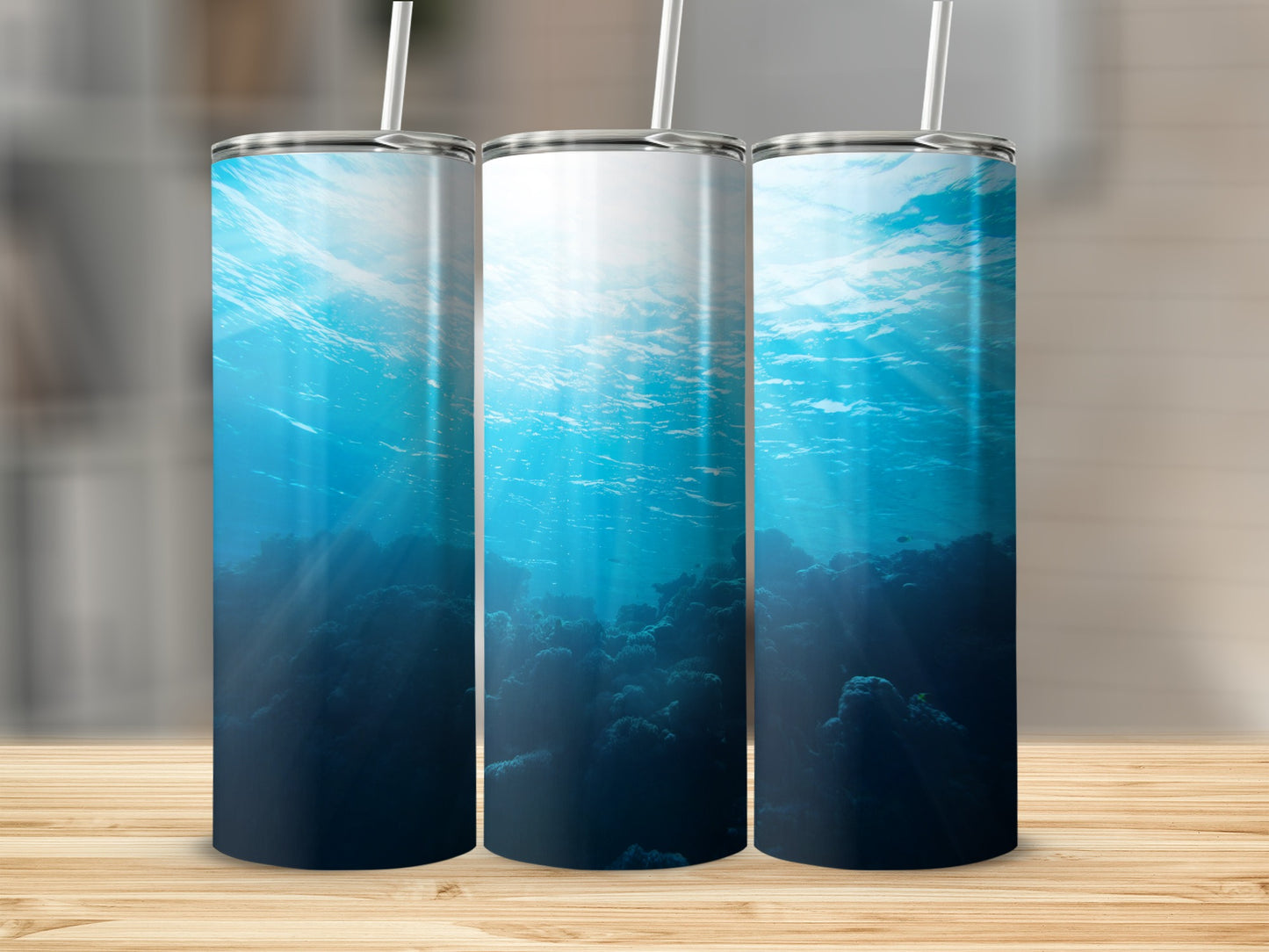 Underwater scene with coral and sunbeams, on three tumblers.
