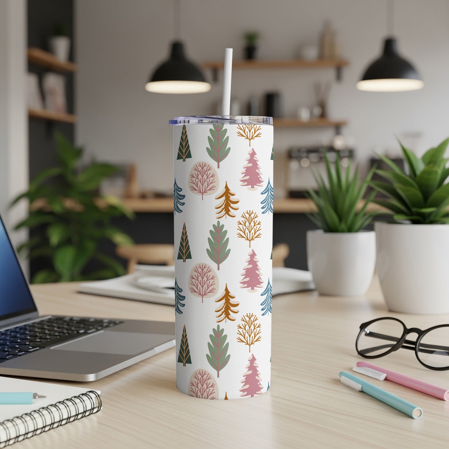 White tumbler with festive tree pattern and straw.