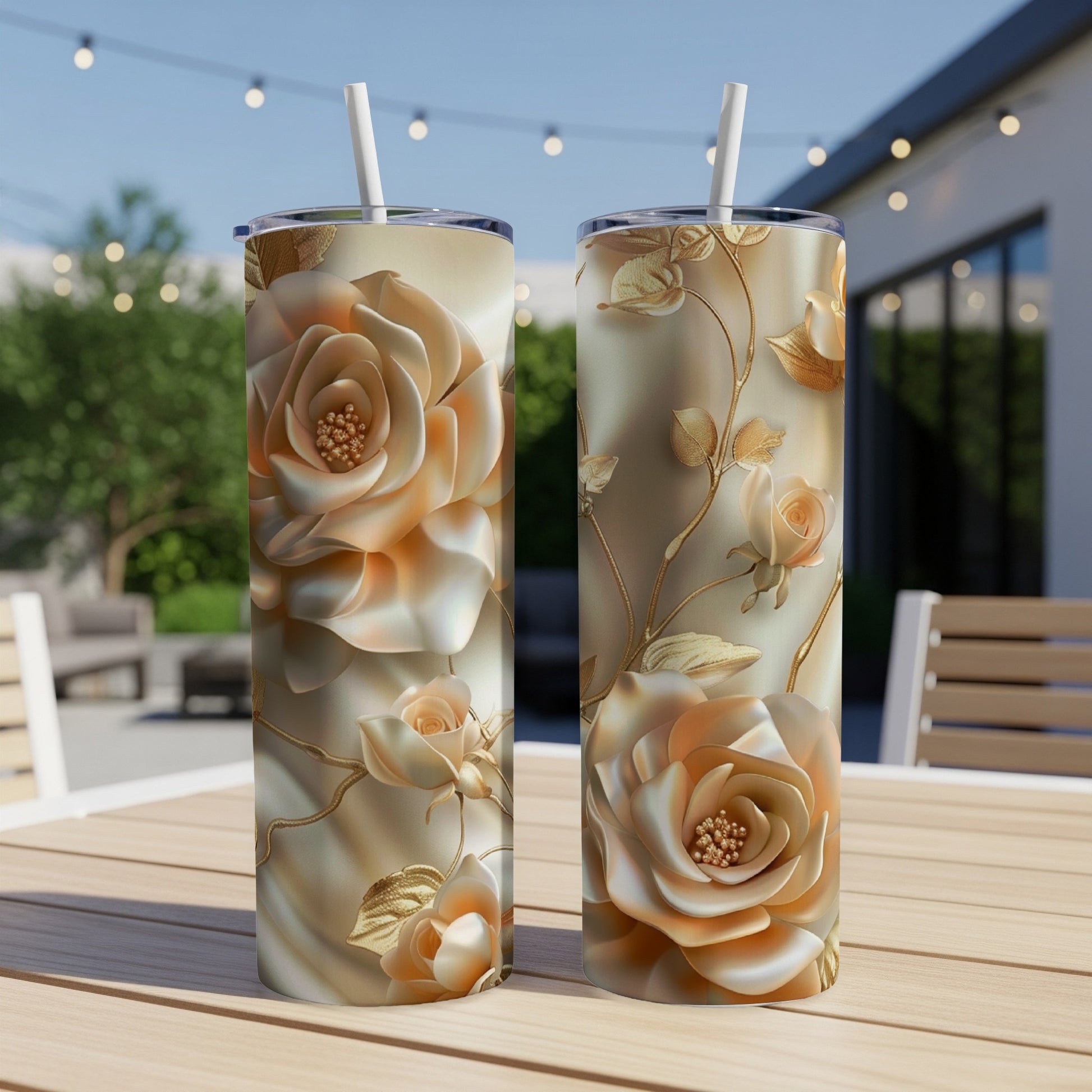 Two gold-toned tumblers with raised rose and vine designs on a wooden table.