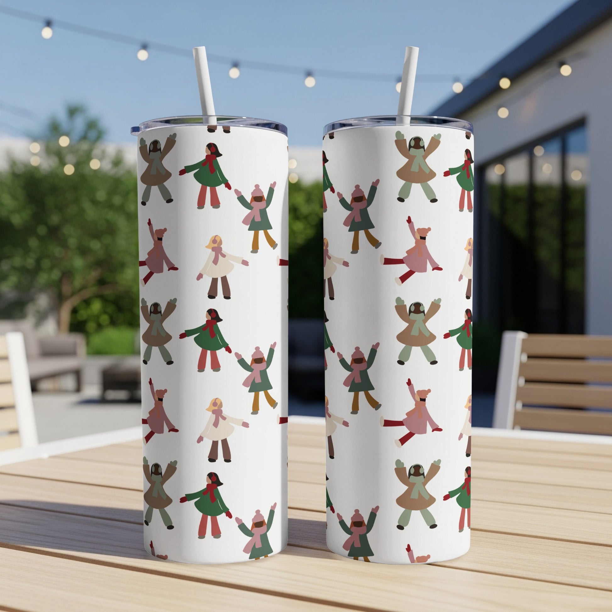 Two white tumblers with a playful pattern of diverse, smiling cartoon figures.