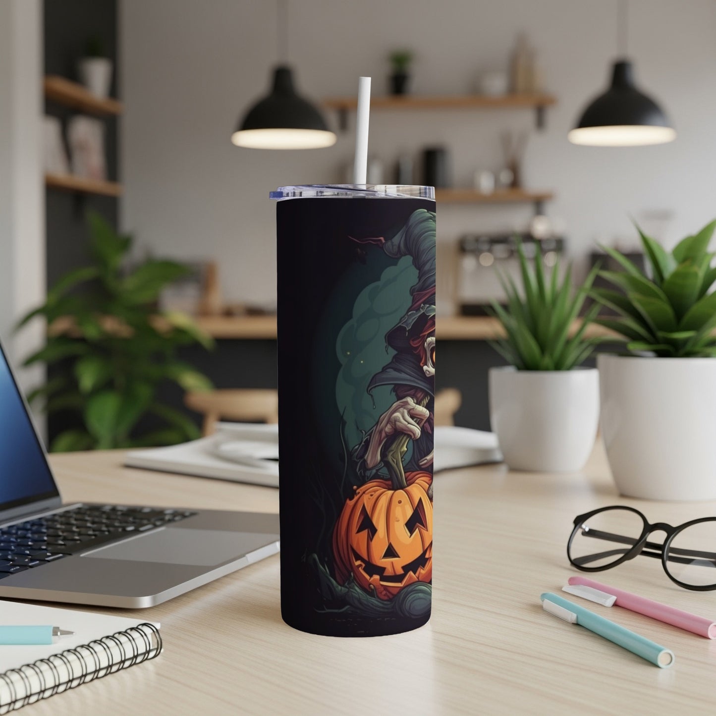 Tall tumbler with a witch holding a jack-o'-lantern illustration on a dark background.