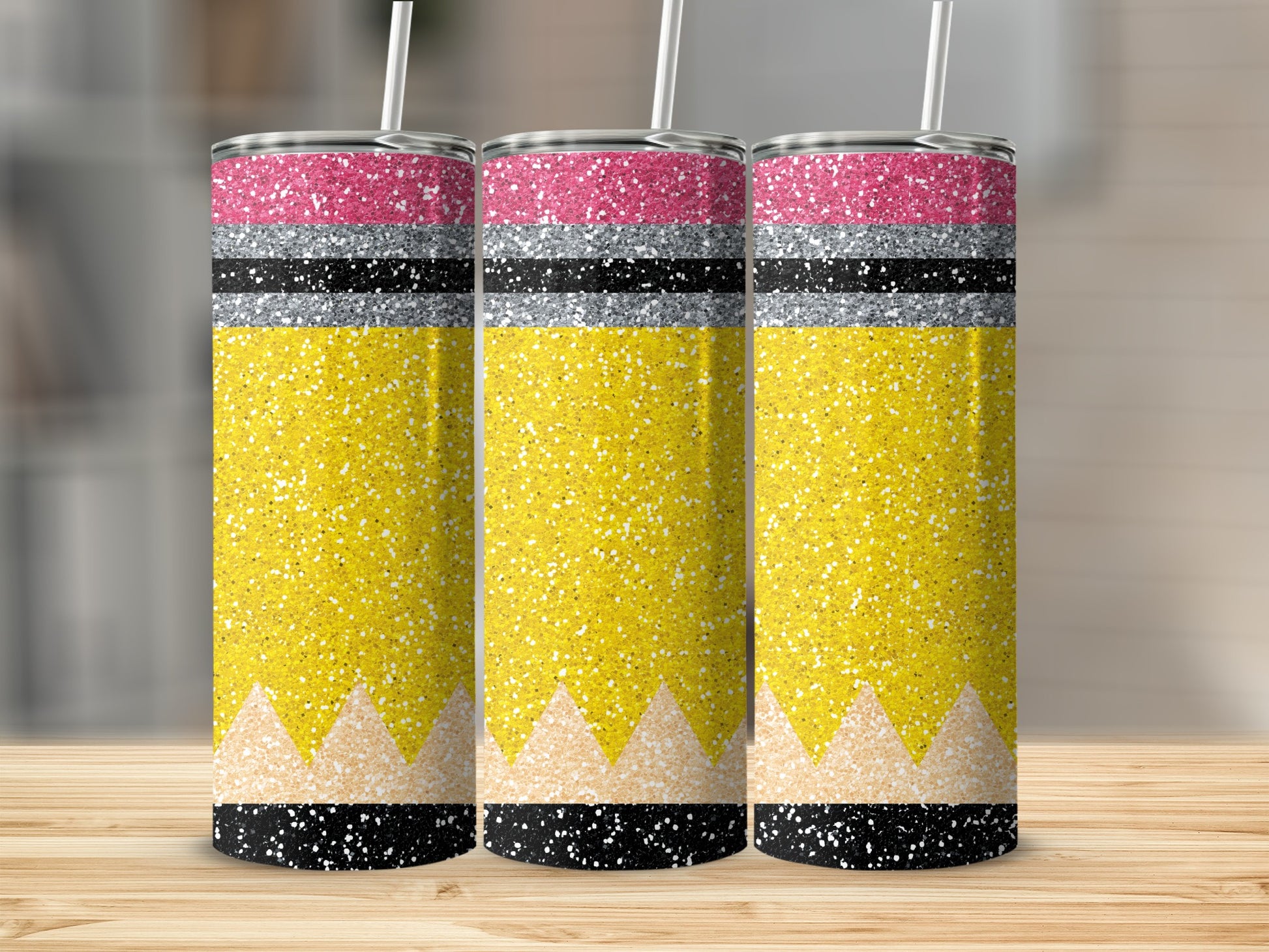 Three glitter pencils with yellow bodies and pink and silver bands.