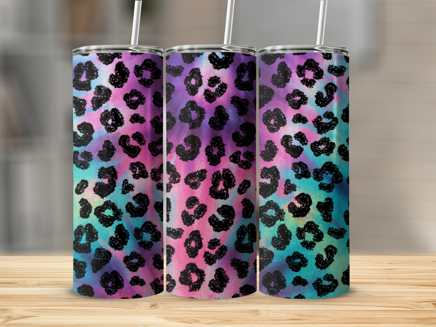 Three tumblers with black leopard print on a tie-dye background of pink, purple, and teal.